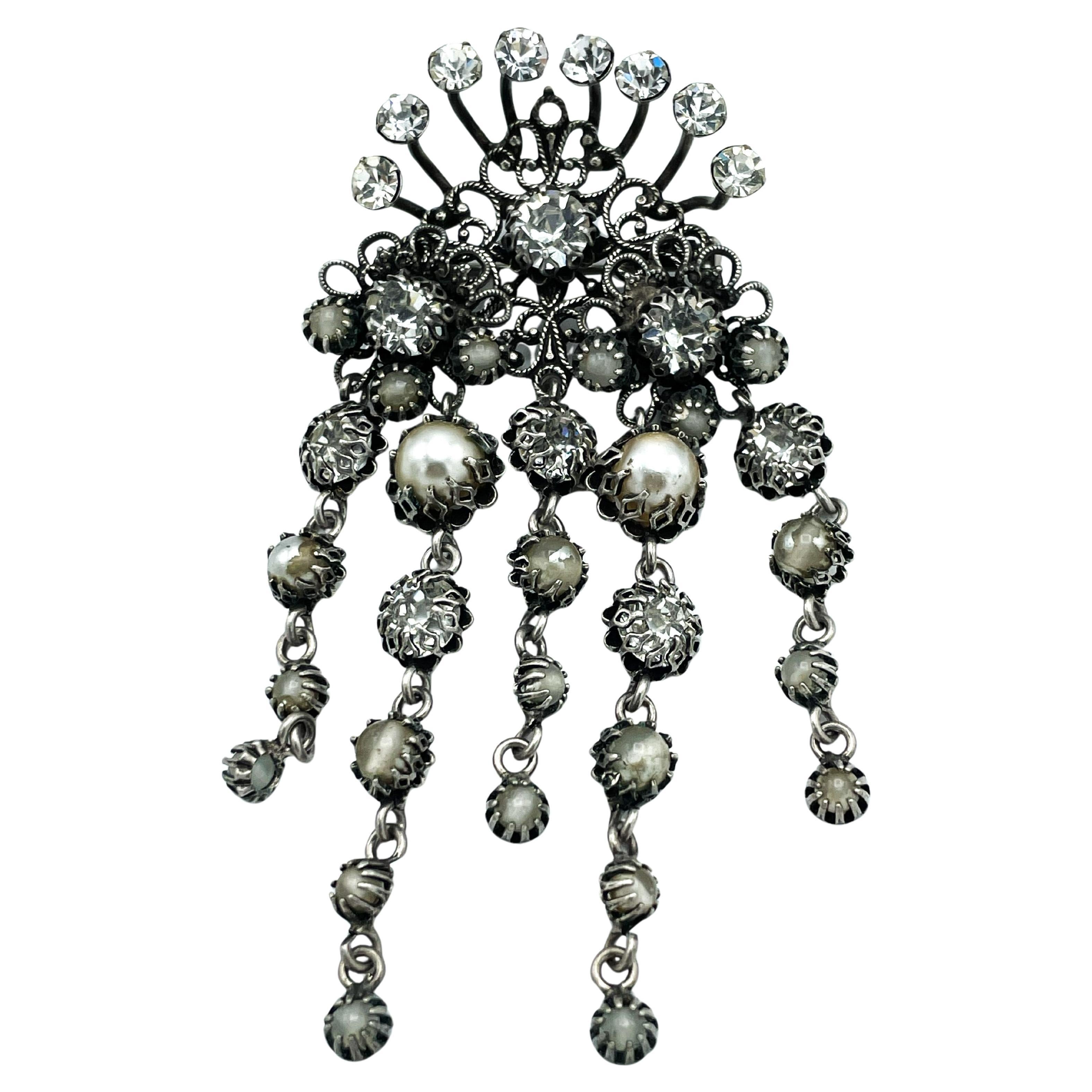 Rare broche signée de la comtesse CIS Zoltovska, datant des années 1950, avec de nombreux strass et 5 glands mobiles. Très bon état !

Dimensions :
Wight    4.3 cm 
Hauteur     9   cm 
Glands  4 et 6 cm de long.
