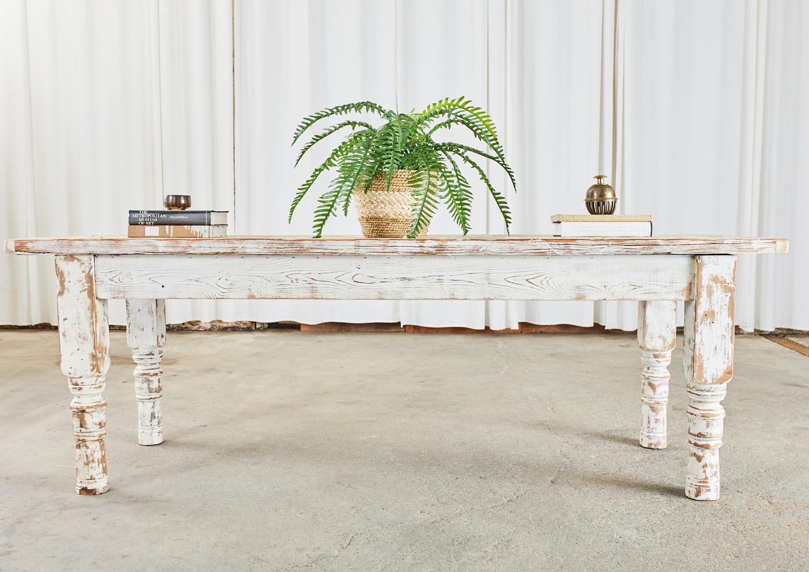 Rustic country American painted farmhouse dining or harvest table. Constructed from reclaimed pine the long top is made from 2 inch thick planks with breadboard ends. Ample leg room measuring 24.5 inches high from the floor to the apron. The table