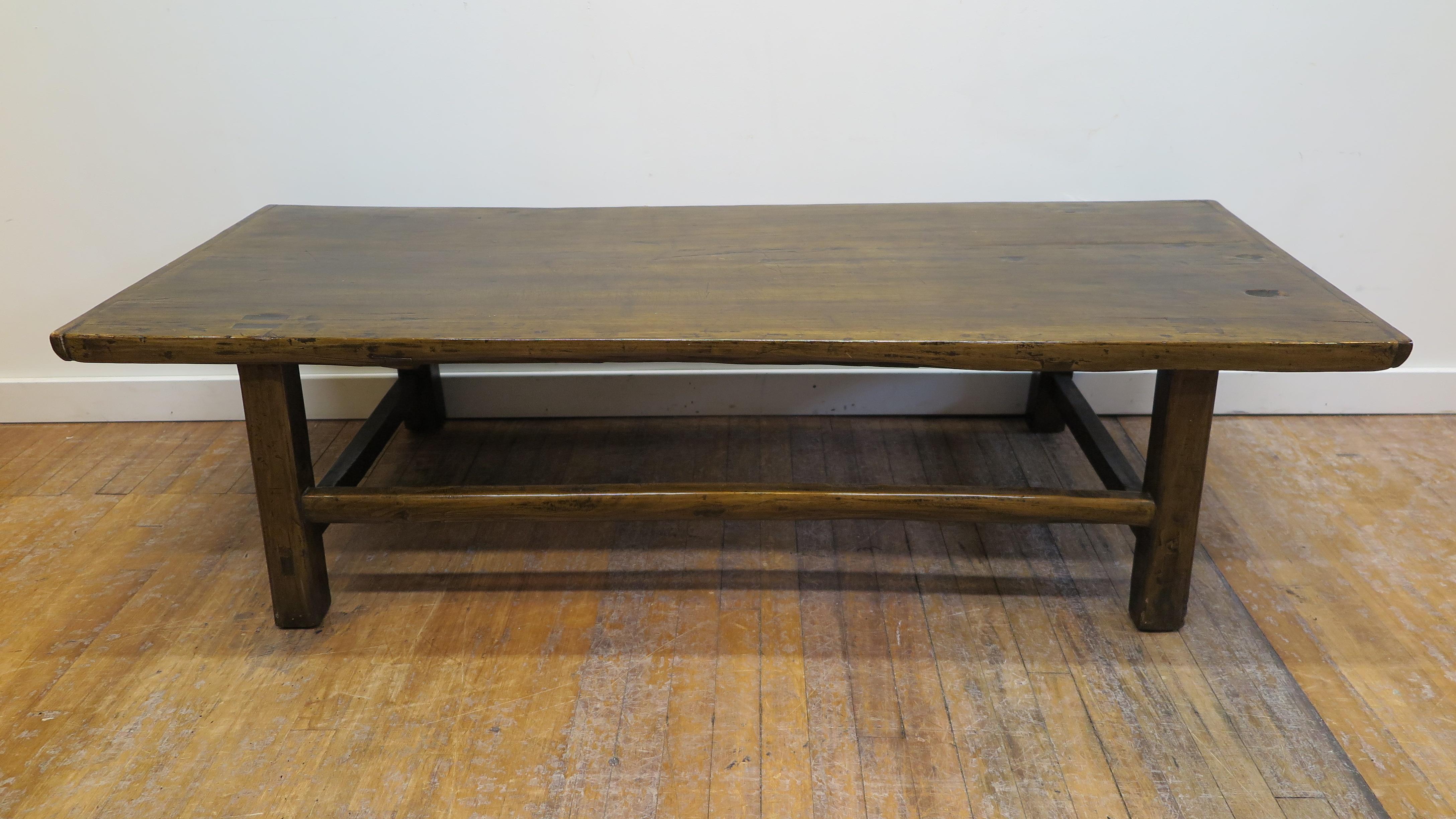 Early 20th century country coffee cocktail table. This antique country low table with splayed legs and tenon mortise construction of Poplar wood makes a great coffee or cocktail table. The table has a lacquer finish that captures the age worn patina
