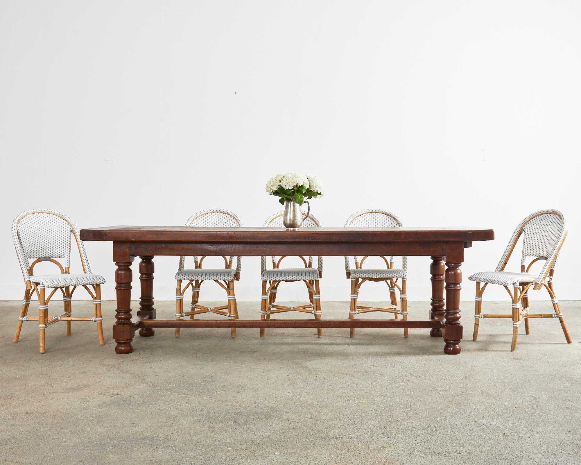 Grand late 19th century country English provincial oak farmhouse dining table constructed on a massive scale. Very heavy and solid featuring a 2.5-inch thick top with bread board ends. The top is supported by a trestle style base with an 18 inch