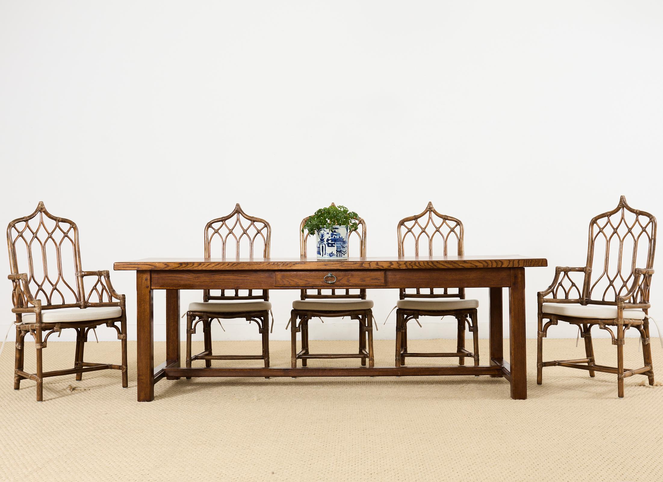 Imposing country English provincial style trestle dining table or library table hand-crafted from oak. The rectangular top features 2 inch thick planks that showcase the rich oak grain patterns. The apron has a small storage drawer on one side with