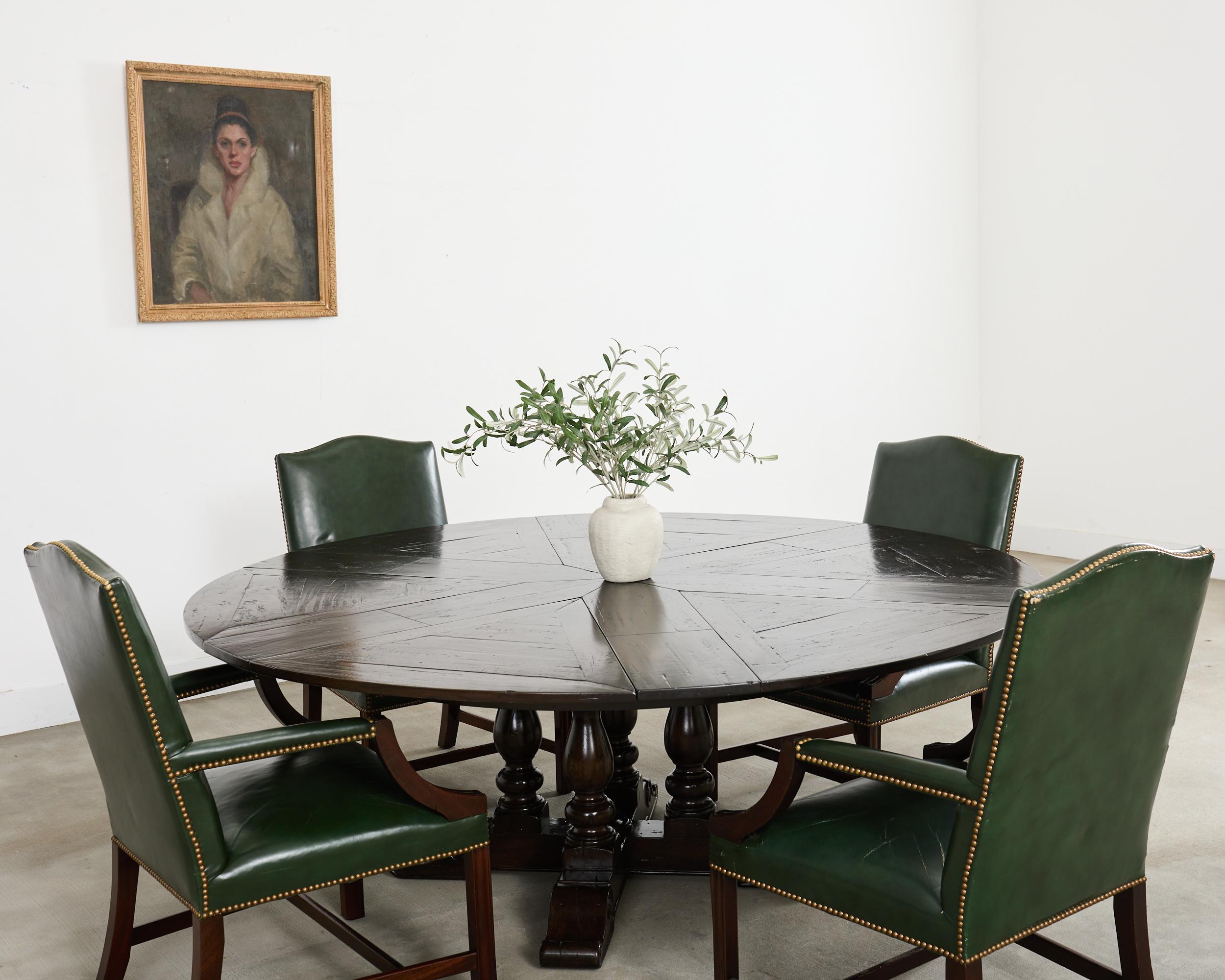 Handsome Castle Bromwich Sylvan round mahogany dining table hand-crafted by Theodore Alexander. The table features an ingenious extending parquetry segmented round circular top with self -storing hidden fold out leaves that extends from a 62.5 inch
