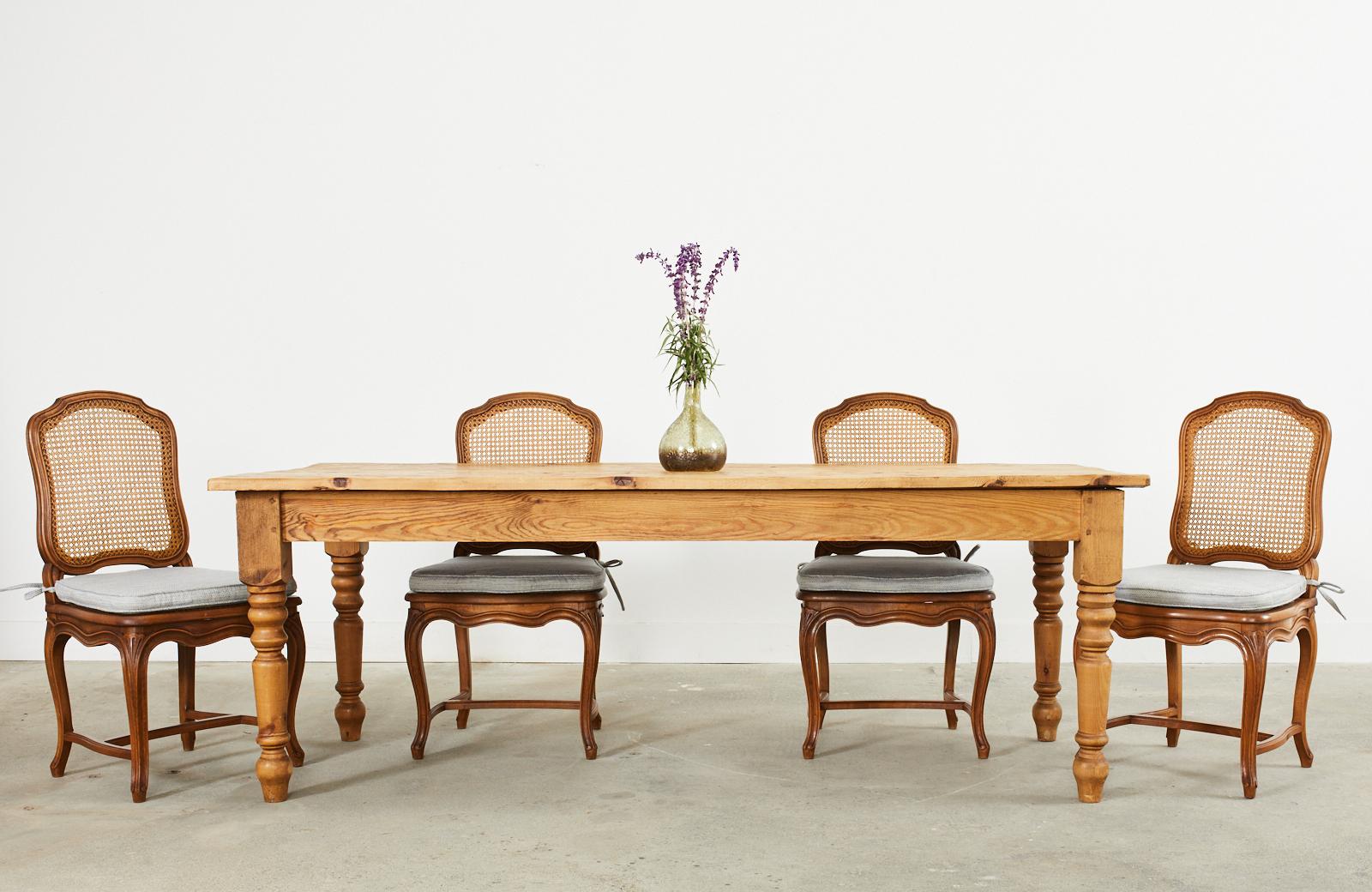 Handsome pine farmhouse dining table or harvest table made in the country English style. The top is crafted from 1 inch thick reclaimed barn wood with a beautifully aged patina and natural finish to showcase the weathered woodgrains and knots in the
