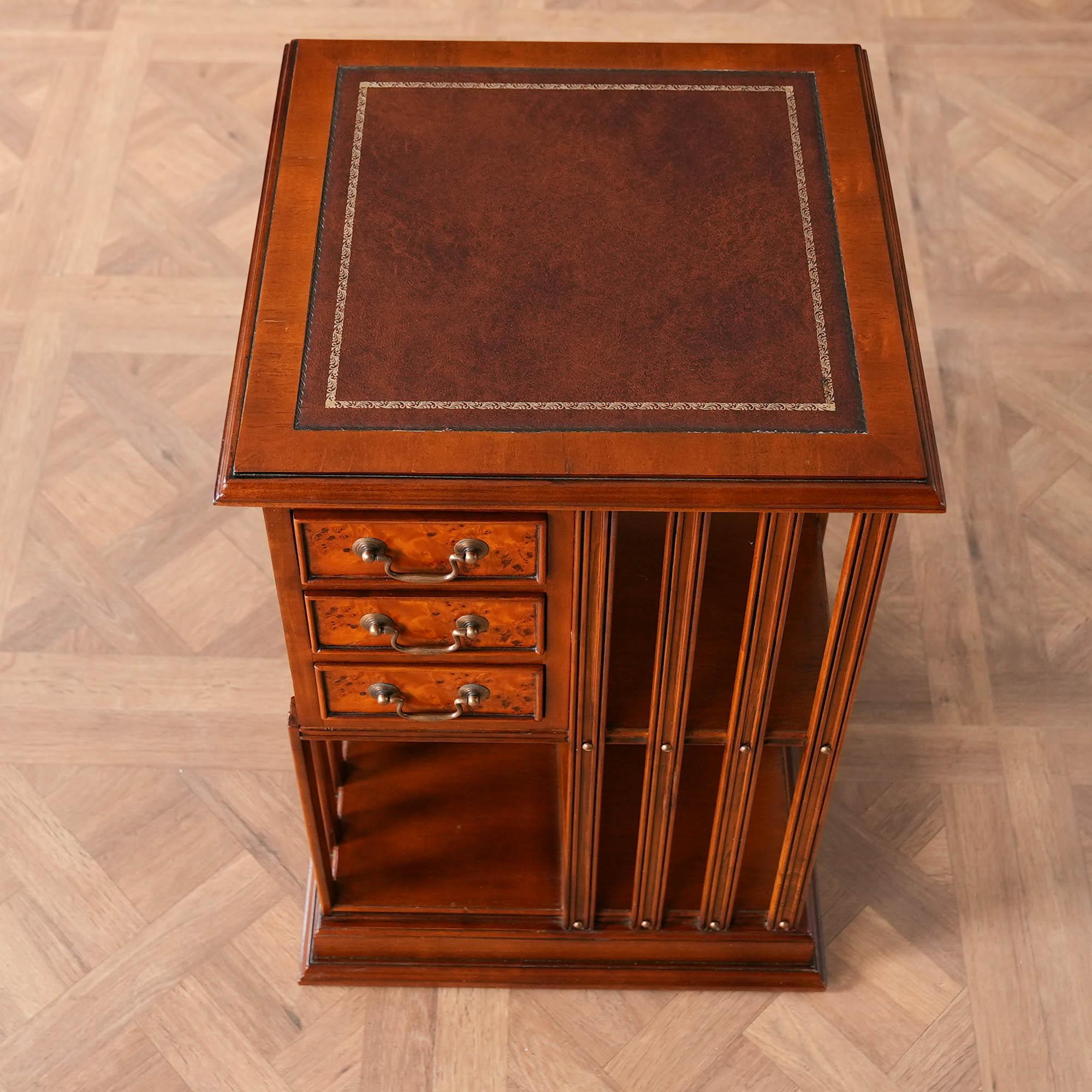 A Country Estate Revolving Bookcase from Niagara Furniture with full grain leather top with a shaped molding surround, over top three dovetailed drawers and numerous supported storage spaces, all accented with brass headed screws and hardware. The