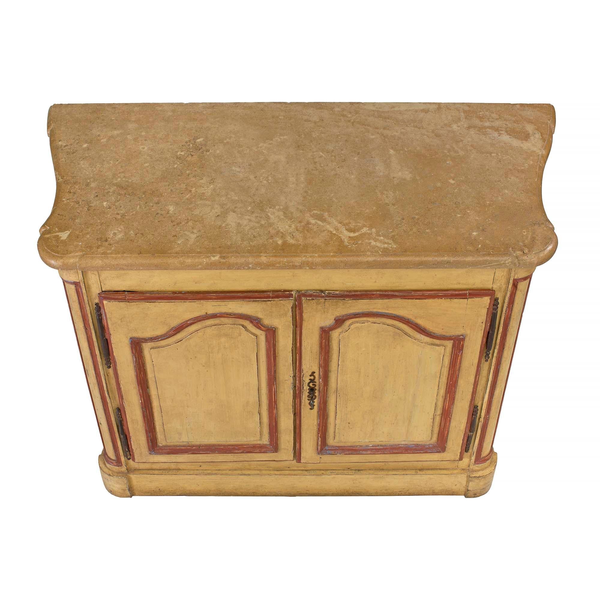 Un très joli buffet de style campagnard français du XVIIIe siècle patiné. Le buffet à volutes de couleur blé a deux portes à panneaux avec des bordures rouges. La poignée en fer patiné s'ouvre pour révéler une étagère intérieure et une serrure. Le