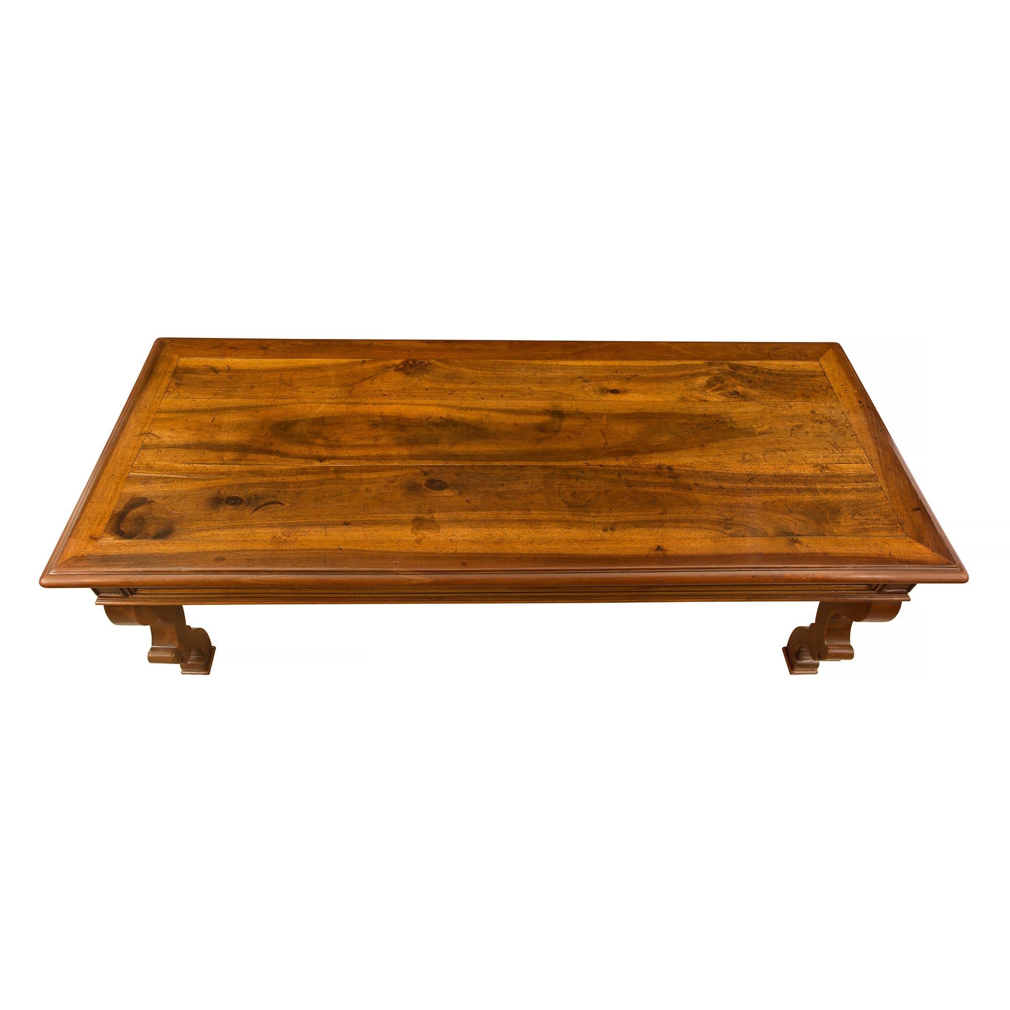 A very handsome rectangular 18th century country French solid walnut center/dining table. The table is raised by 'S' scrolled legs. The frieze decorated with molded trim has two drawers one on each side with the original iron pulls. The top has a