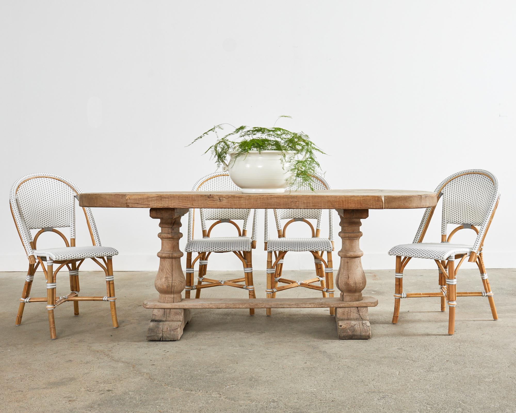 Substantial country French farmhouse dining table featuring round demilune ends. Beautifully crafted from thick, solid oak with an aged, weathered bleached finish. The plank top is 3 inches thick with notched demi-lune form ends. Supported by a