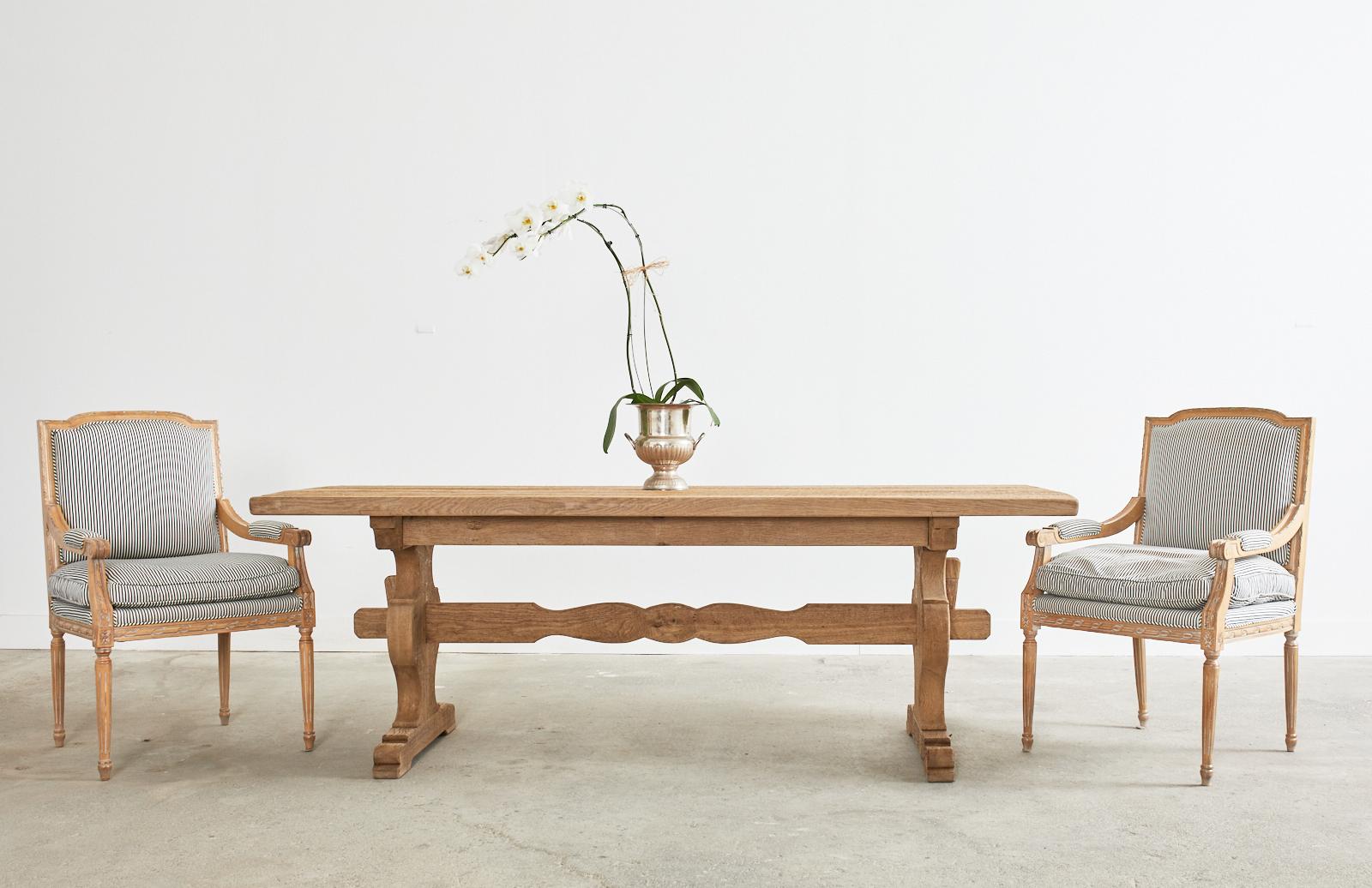 Impressive country French provincial farmhouse dining table featuring a bleached oak finish. The rectangular plank top is 2