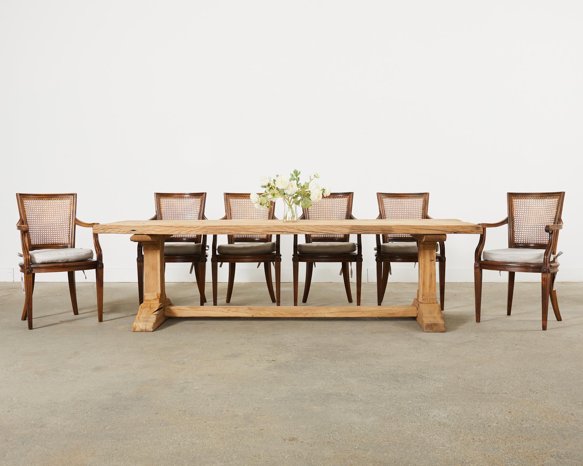 Rustic and weathered country French farmhouse dining table featuring a bleached oak finish. Gorgeous table crafted from 2.25 inch thick oak timbers on the top conjoined with wood peg joinery. Beautifully crafted from distressed wood with strong