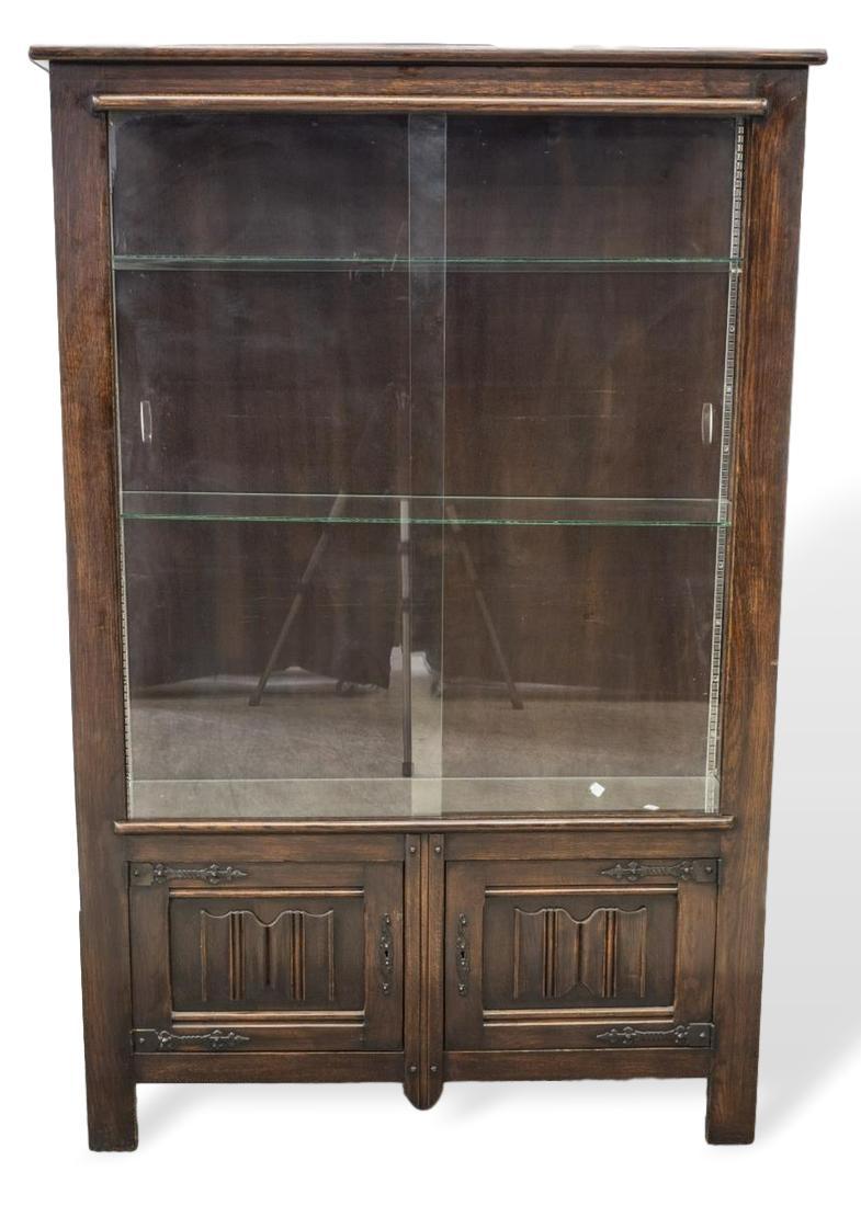 Country French carved oak vitrine display cabinet with Linenfold Panels, circa 1900, with glazed side panels, sliding glass door to front, over double-door cabinets with linenfold carving to panels, with elaborate wrought iron strap hinges and