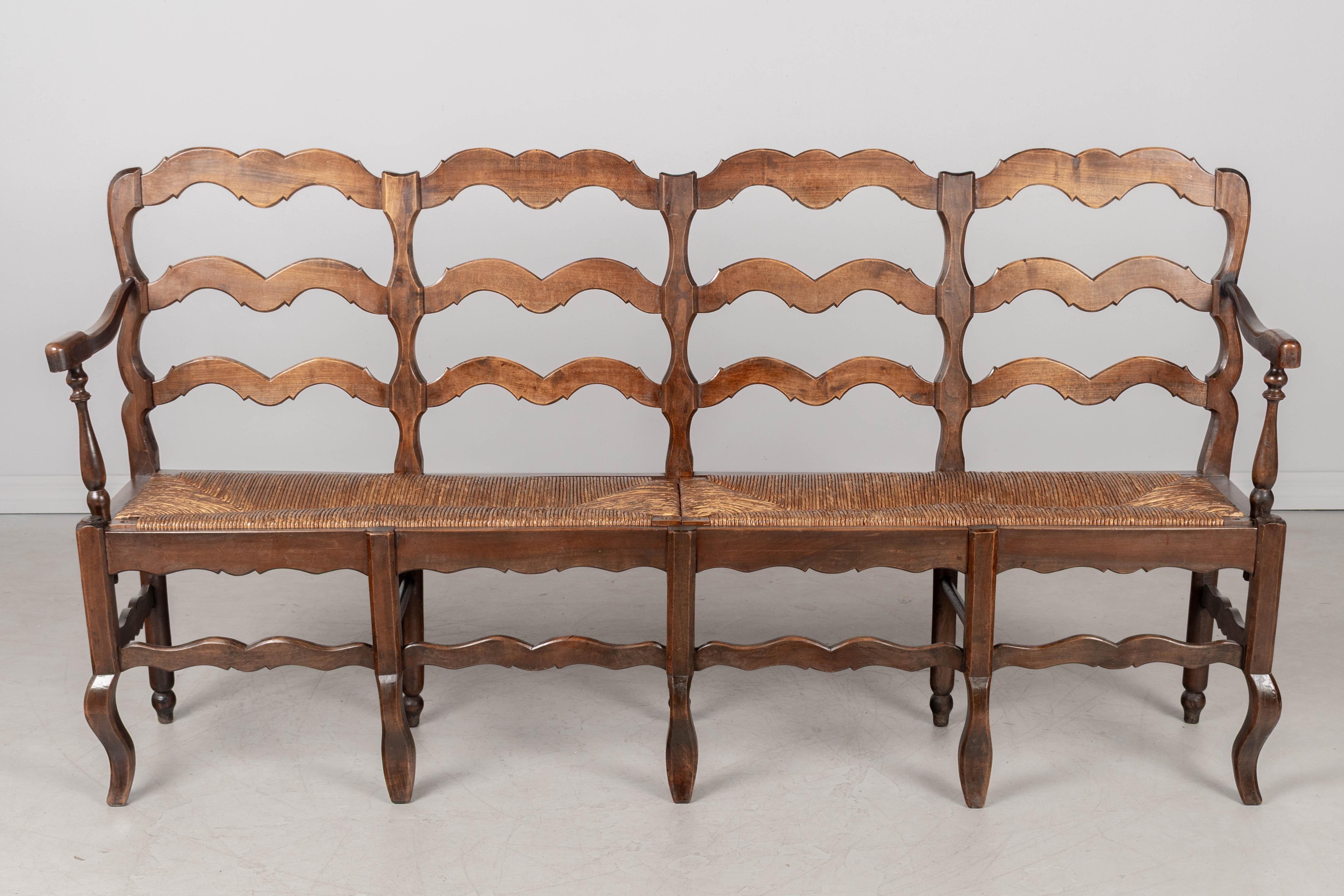 A Country French bench with dark stained beech wood frame and natural rush seat. Right arm repaired. Perfect for a hallway or entryway.
Dimensions: 69