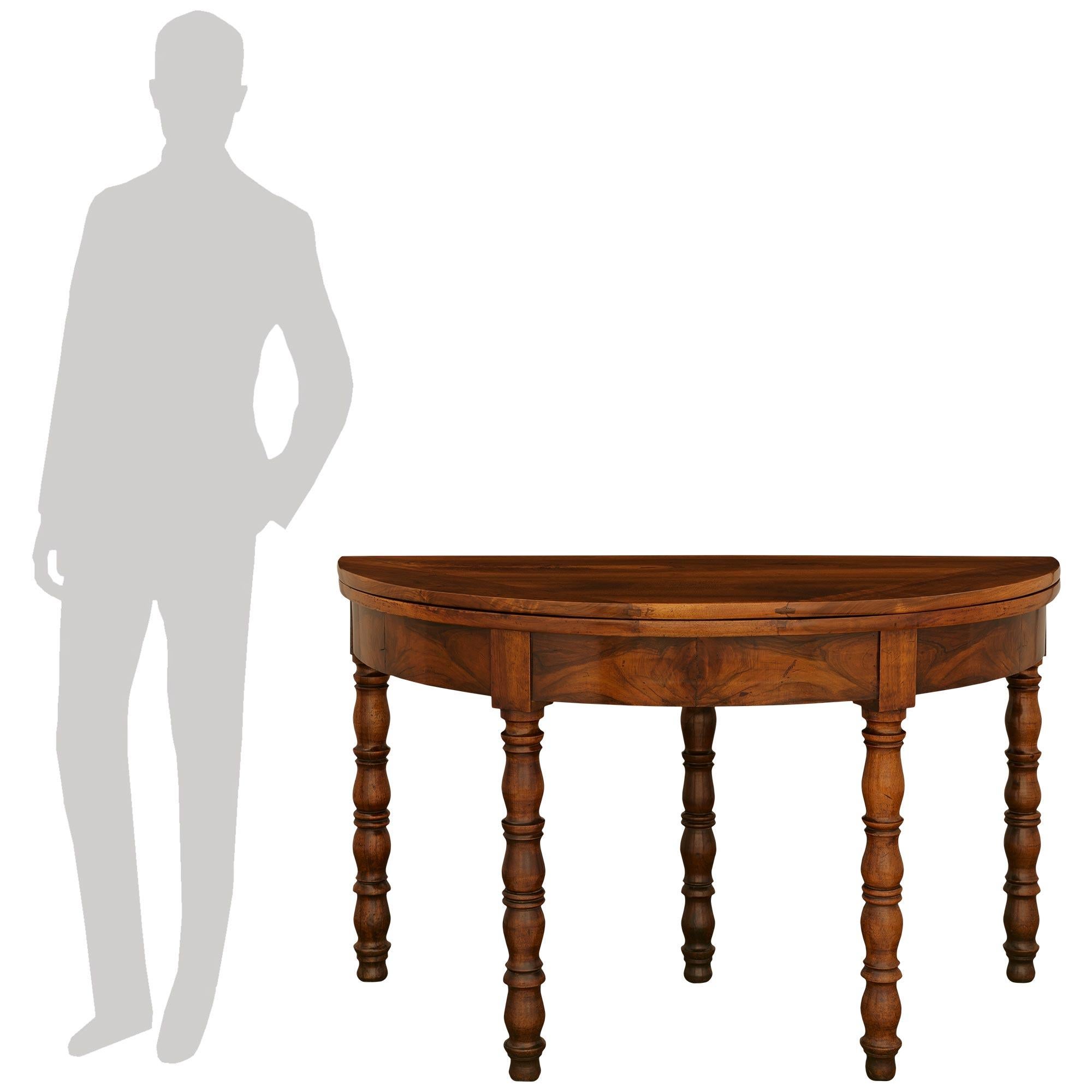 Atractiva mesa de comedor/consola de campo de nogal francés del siglo XIX, de gran calidad y con tapa abatible. La mesa se eleva sobre cuatro impresionantes patas torneadas y una quinta pata extensible en la parte posterior. La mesa tiene un