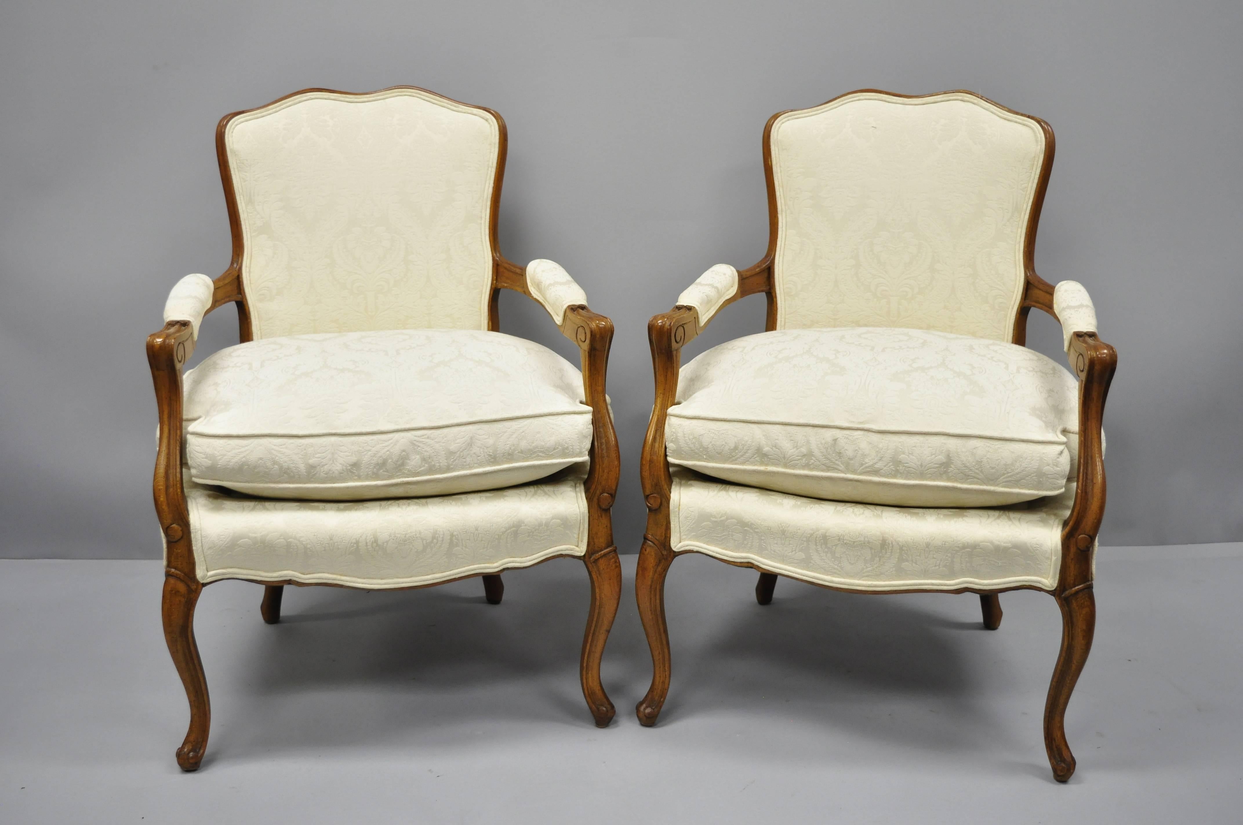 Charming pair of vintage country French Louis XV style fauteuil armchairs with white down Filled cushions. Item features solid wood construction, shapely frames, upholstered armrests, down filled cushions, cabriole legs, and great style and form,