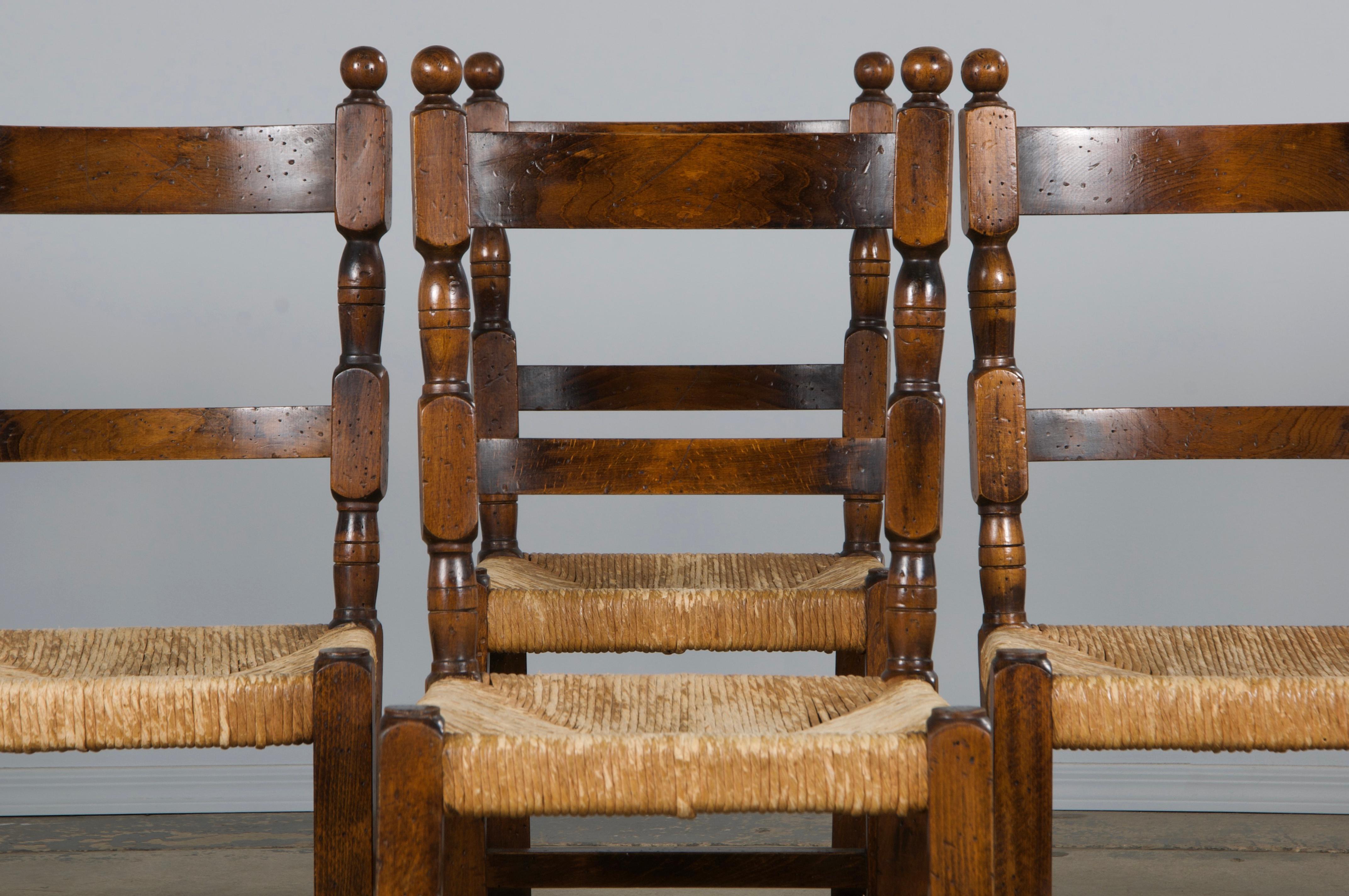 A charming set of eight French farmhouse dining chairs, sourced directly from Provence. Hand-carved from solid maple, these chairs feature an elegant ladder-back design and boast a naturally aged patina in a rich, warm brown color. The chairs have