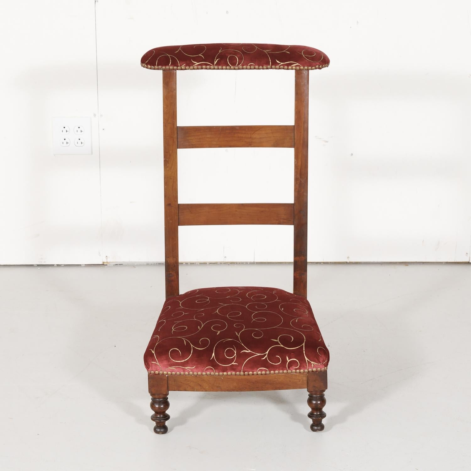 Country French Napoleon III period ladder back prie dieu or prayer chair handcrafted of walnut having the original velvet upholstery, circa 1870s. This charming provincial kneeling chair has its original covered, sloped top to rest one's arms or a