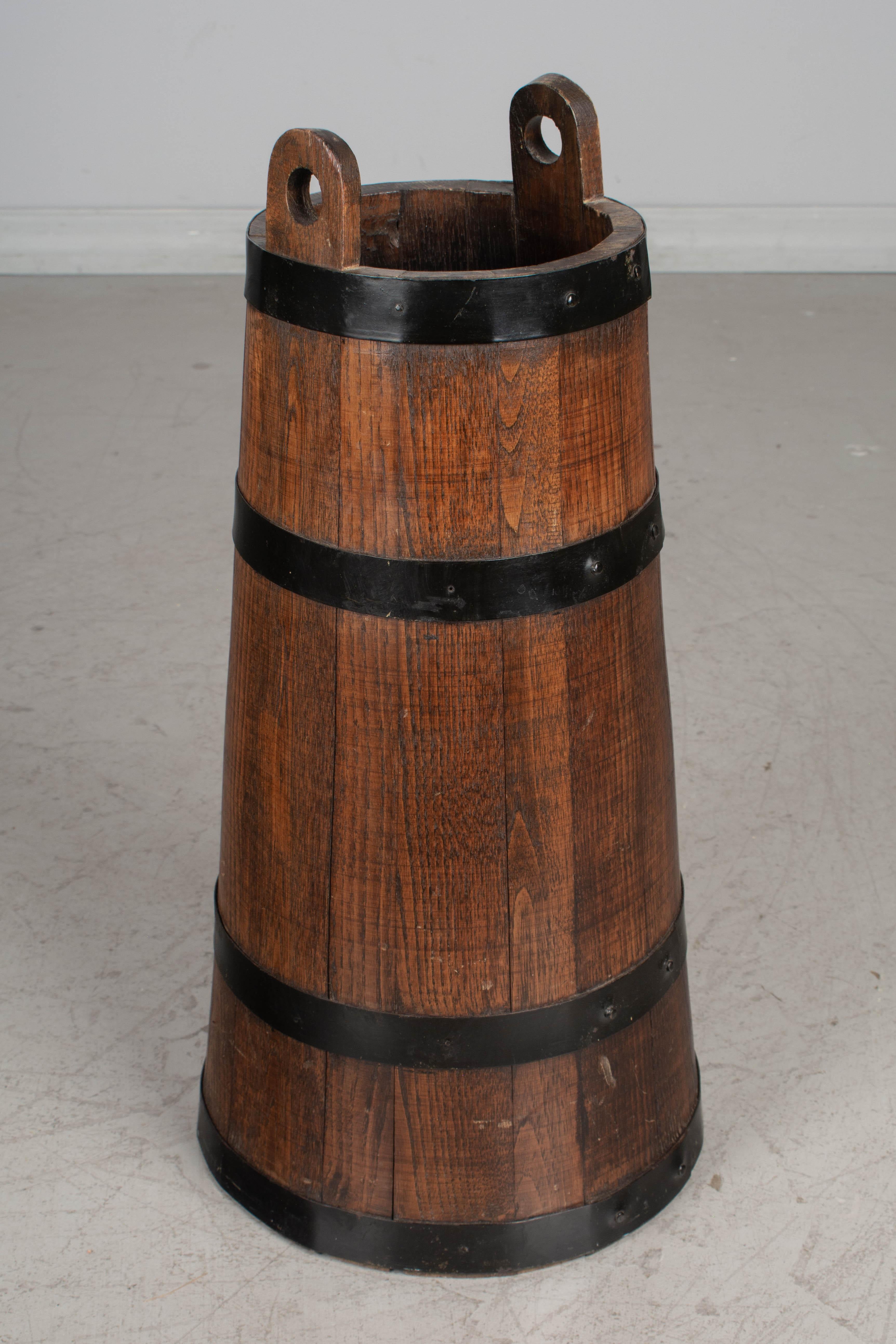 A Country French barrel form umbrella stand from Normandy. Hand crafted of chestnut wood with iron strapping. Waxed patina. A good sturdy container for walking sticks or riding crops. 
Height: 23.5