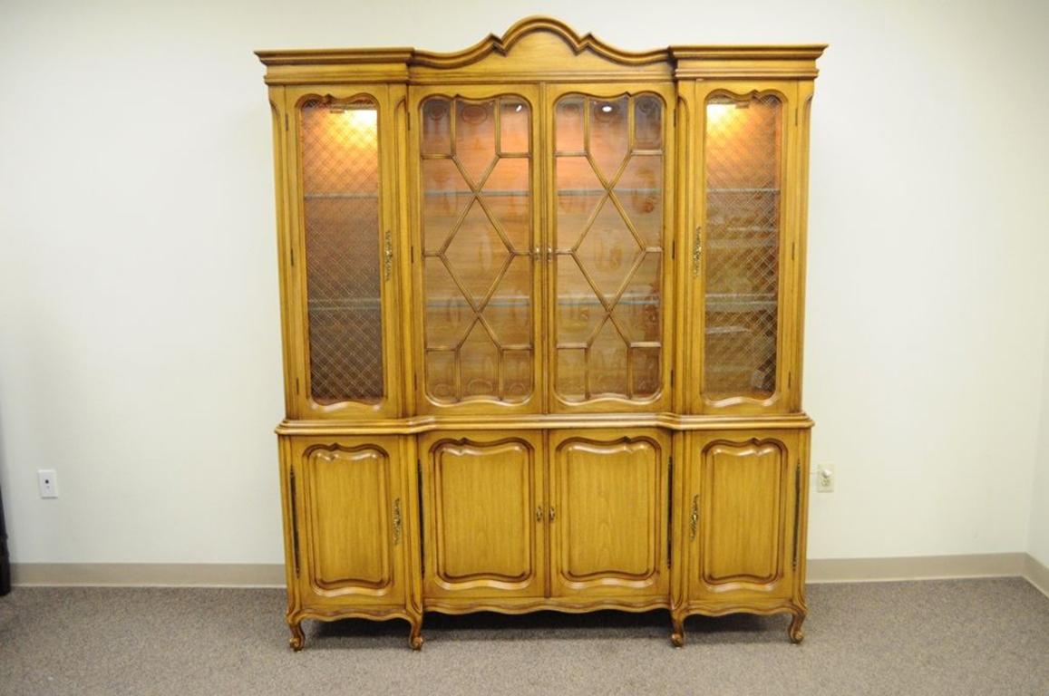 High quality vintage Country French / Provincial two-piece breakfront China cabinet. Item features two-part solid wood construction, interior lights, four upper cabinet doors, four lower cabinet doors, two dovetail constructed hidden drawers, bubble