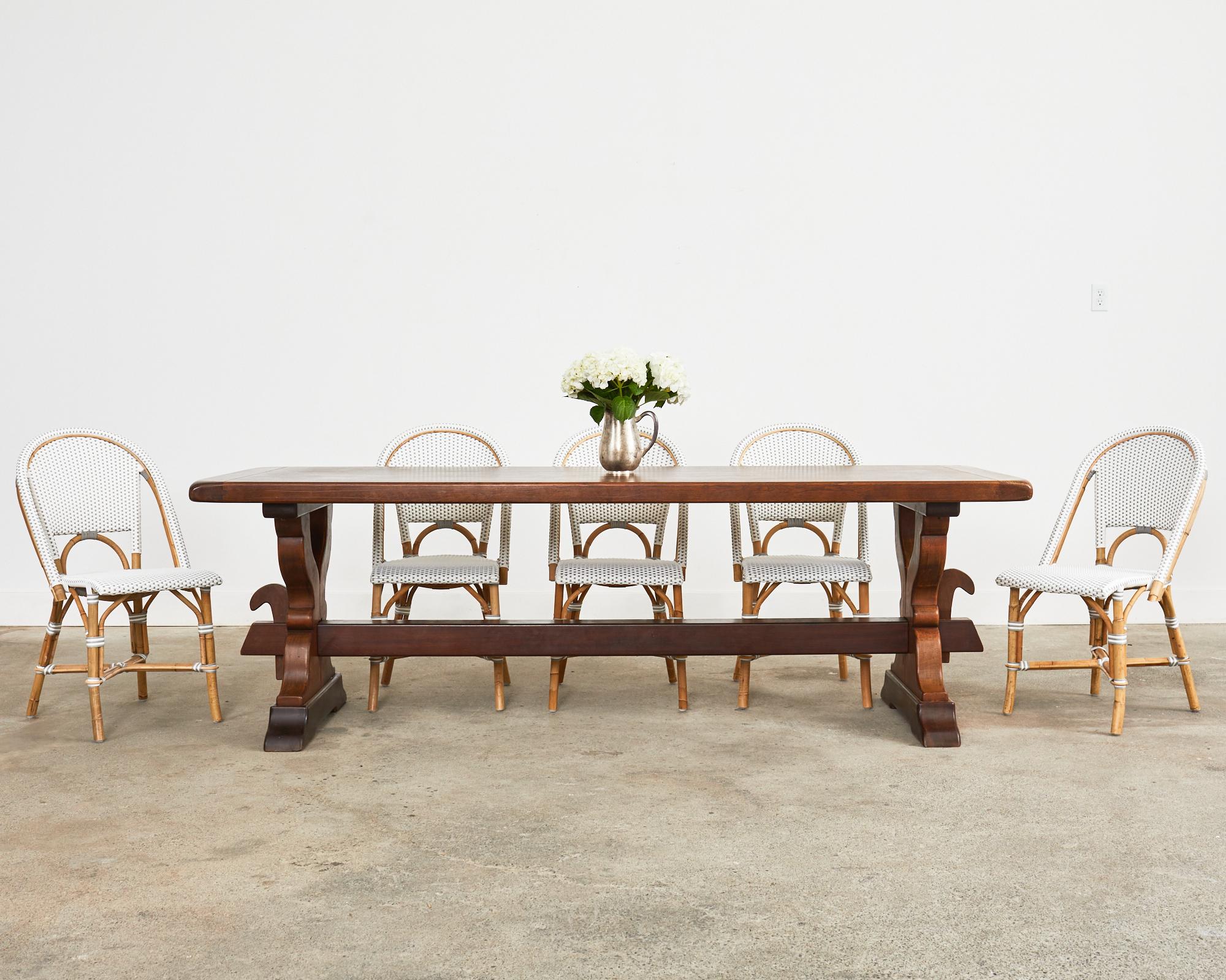 Gorgeous country French provincial oak farmhouse dining table or harvest table crafted from solid oak. The plank top is over 2 inches thick with breadboard ends and supported by a trestle base. The base has gracefully curved legs that end with large