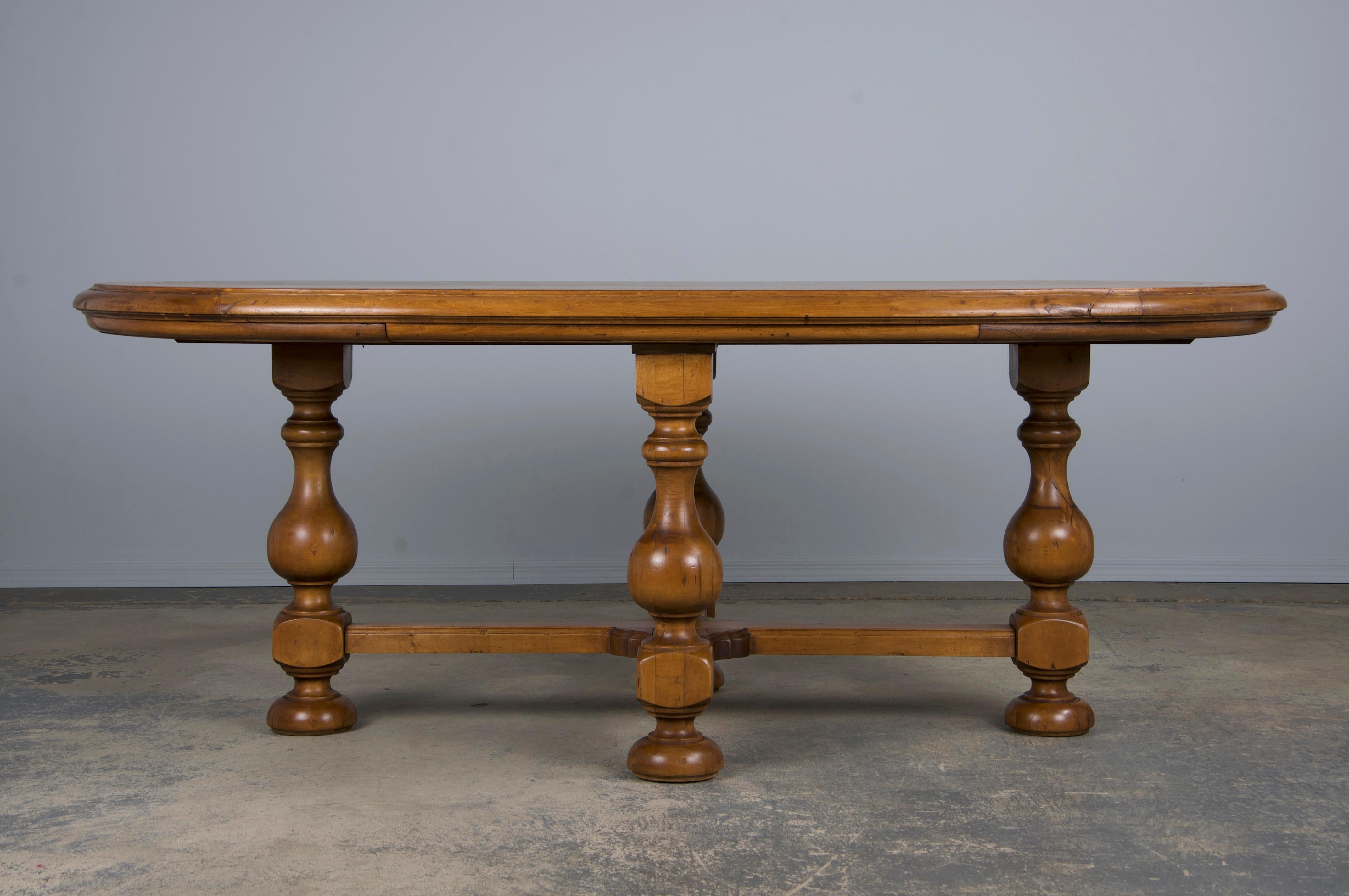 Une élégante table de salle à manger de style provincial français du début du XXe siècle, provenant de Provence, en France. Magnifiquement fabriqué à la main en érable massif, il présente une patine naturelle brun miel et un riche grain de bois. La