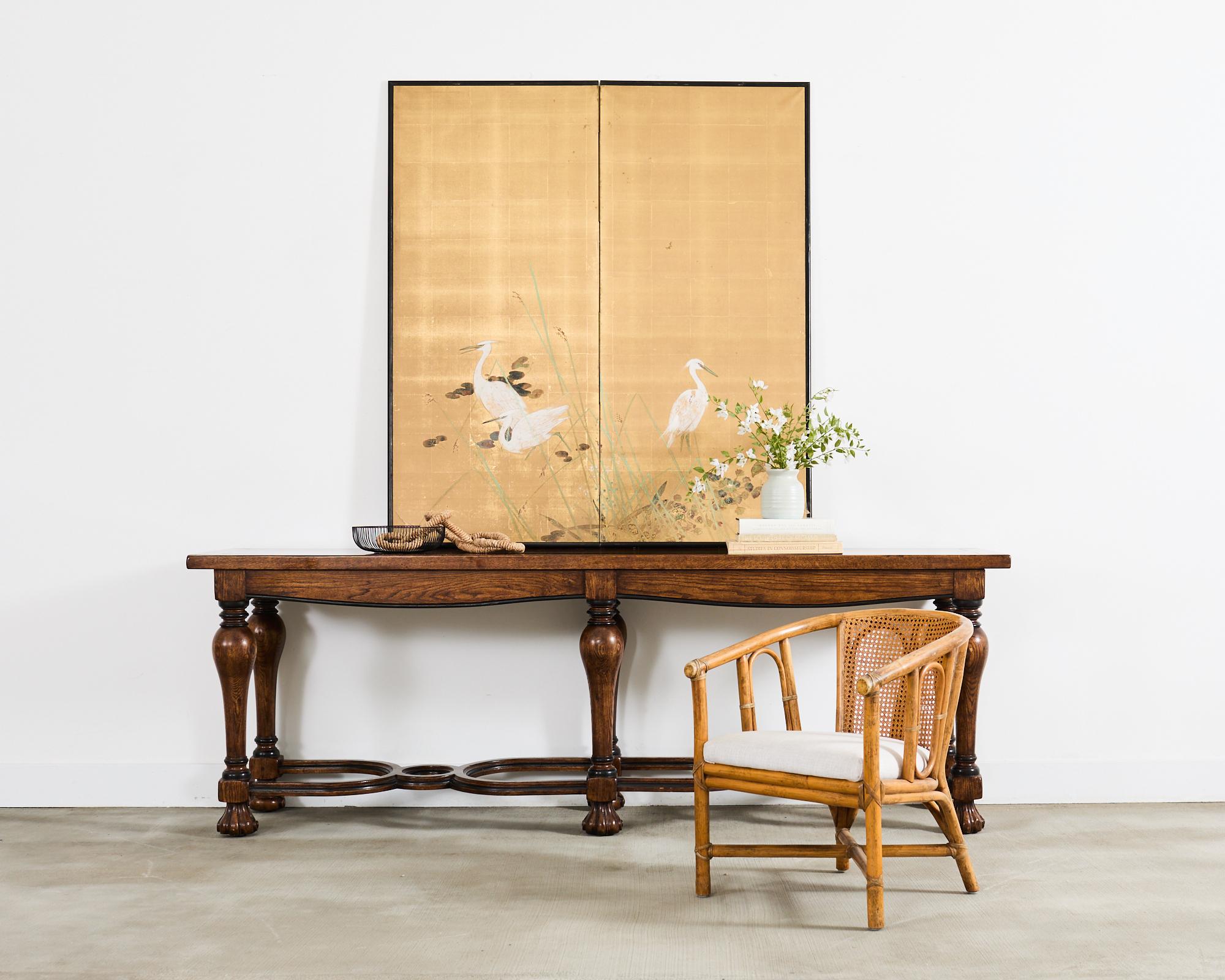 Substantial country French provincial or Louis XIV style console table or sofa table crafted in a refectory style from solid oak timbers. The top measures 1.5 inches thick and is supported by a trestle base having chunky, turned legs. The legs are