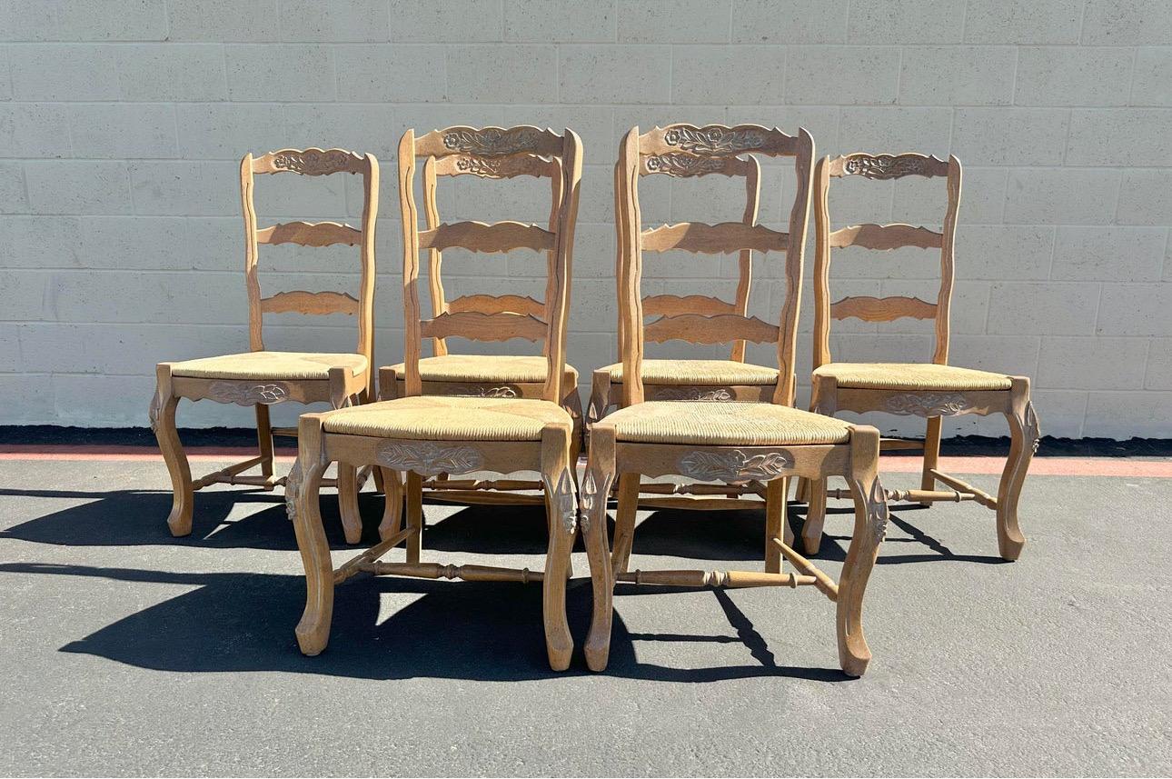 Wonderful set of eight country French ladder back dining chairs with woven fiber rush seats. They are two arm chairs and six armless chairs. These beautiful chairs are original from the 1950’s. The chairs are in good shape, all seats are in