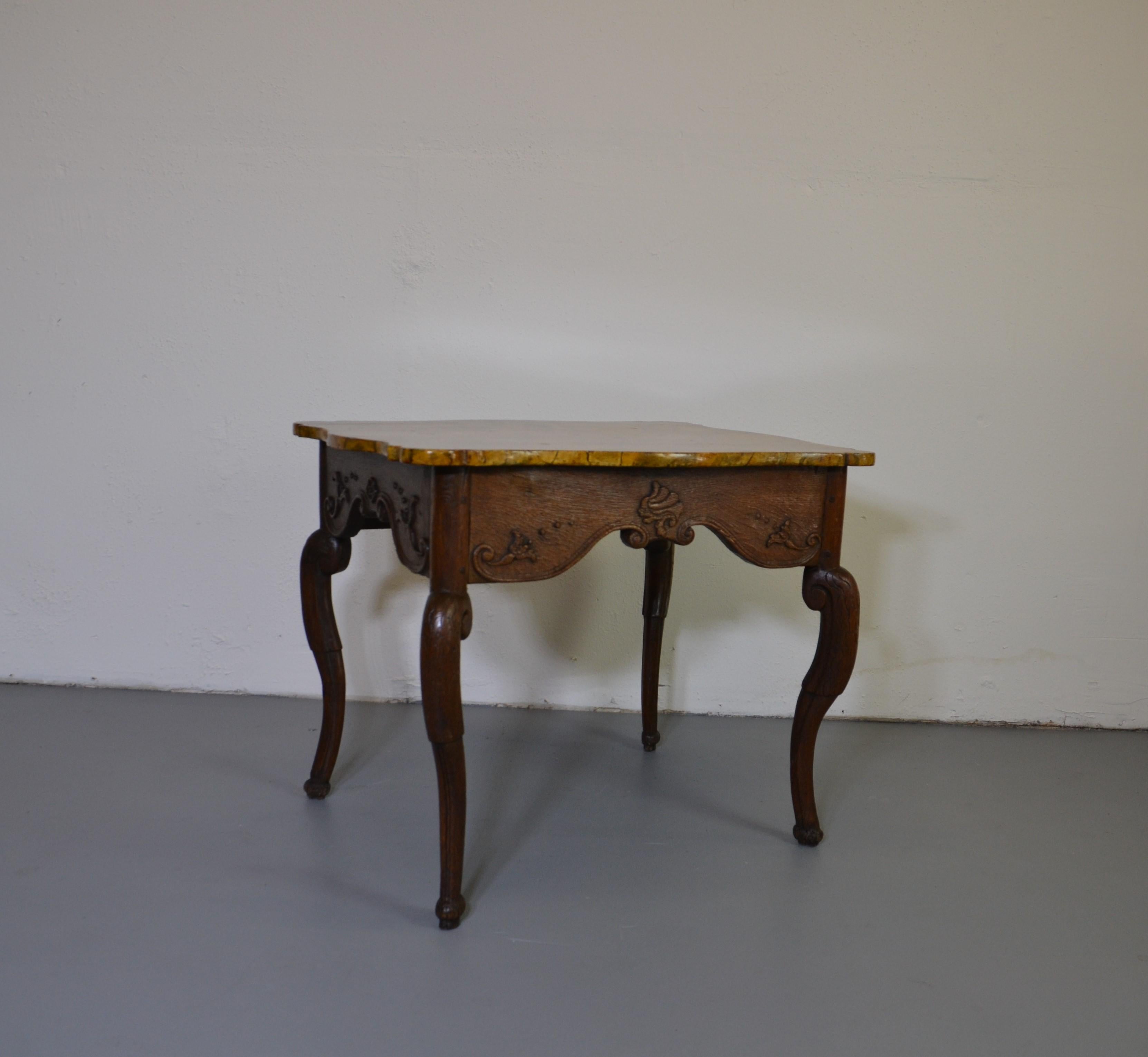 A nice French Provincial side table with a faux marble top. Well shaped legs and Fine carvings. c. 1780.