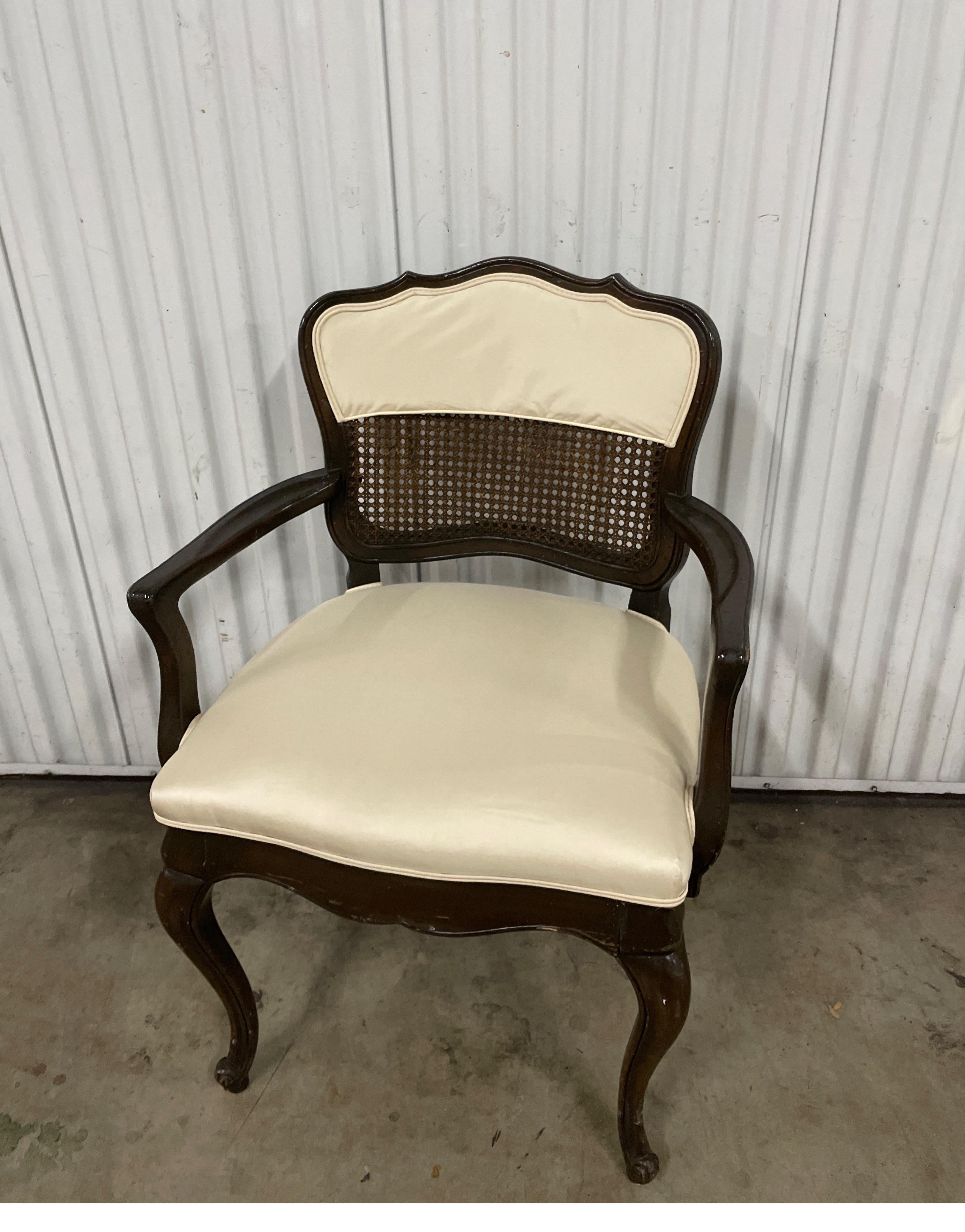 Vintage Louis XVI style Country French Armchair with new upholstery. A complete cane back with partial fabric at top.