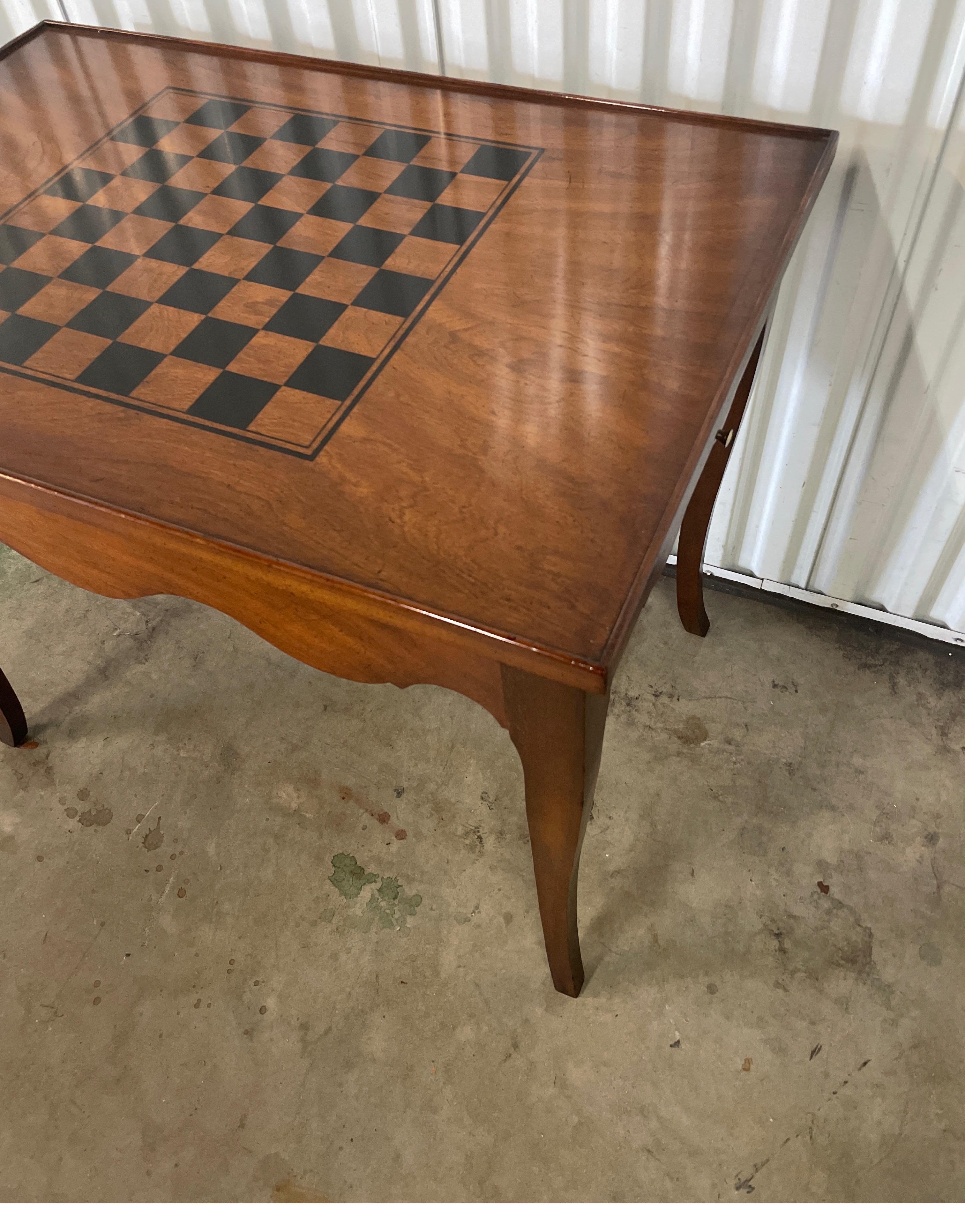 Louis XV style game table with a chessboard top. The top removes to reveal backgammon interior. There is a scalloped apron and pull outs on each side.