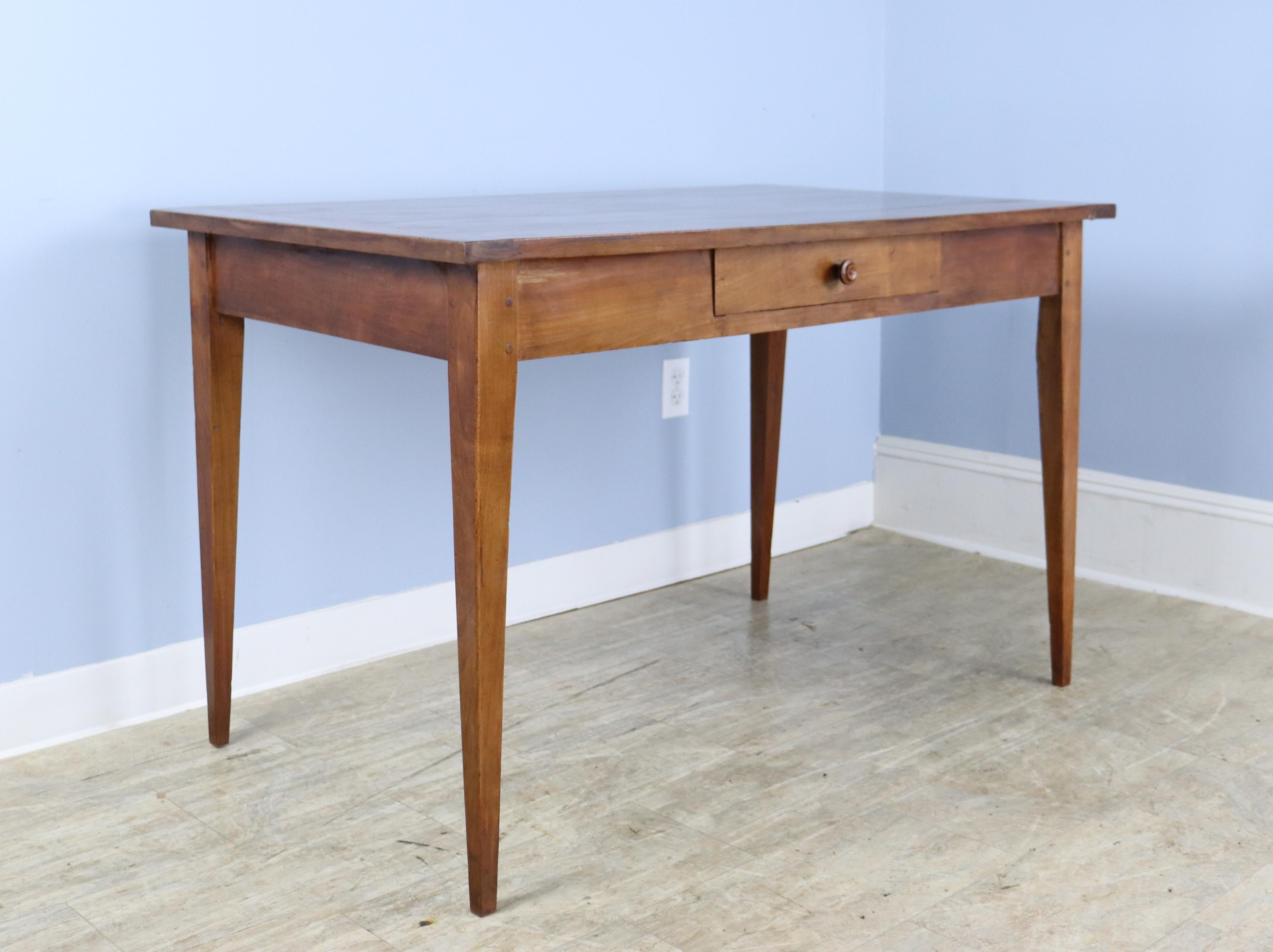 A simple, elegant and beautifully grained fruitwood writing table or desk. This piece is in very good antique condition with few flaws and a handsome presence. 25 inch apron height is just right for knees.