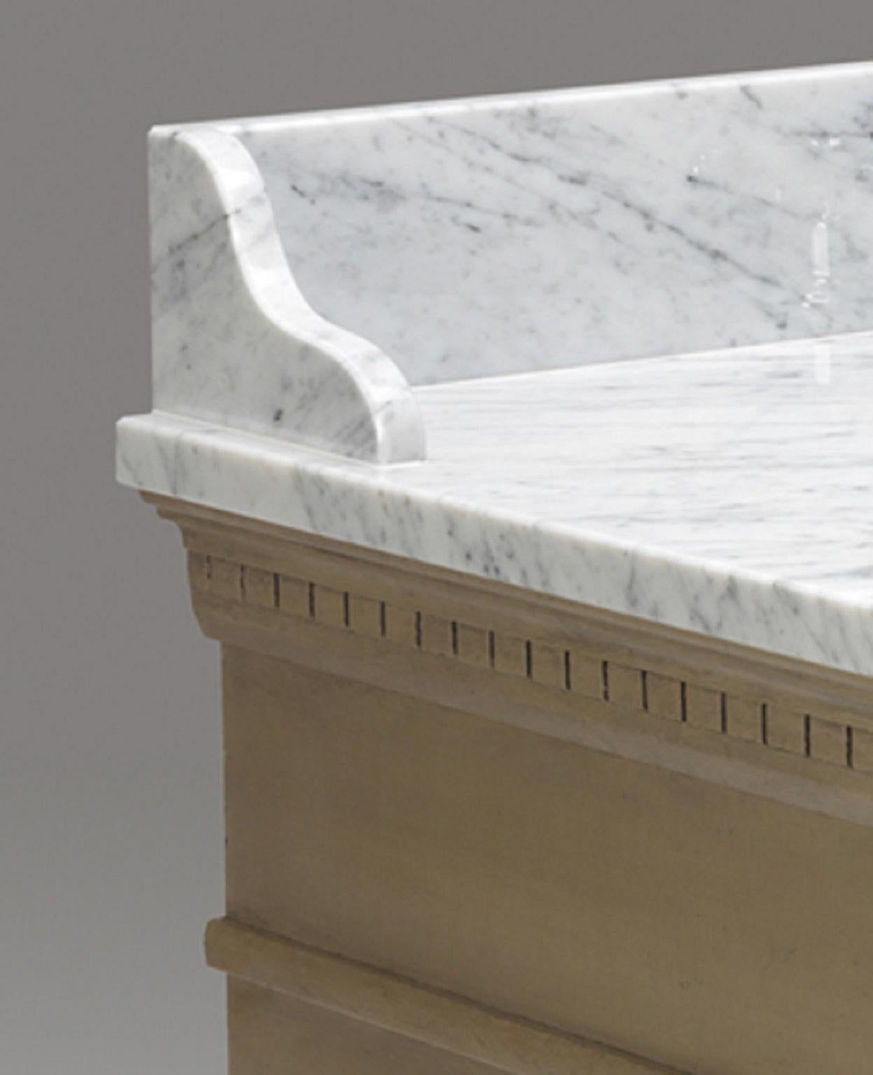 Un armadio vanity con piano e alzatina in marmo. Il mobile ha una modanatura a dentello e un cassetto superiore a forma di manichino. Le due ante apribili sono decorate con perline e poggiano su un piedino tornito. Questo mobile può essere