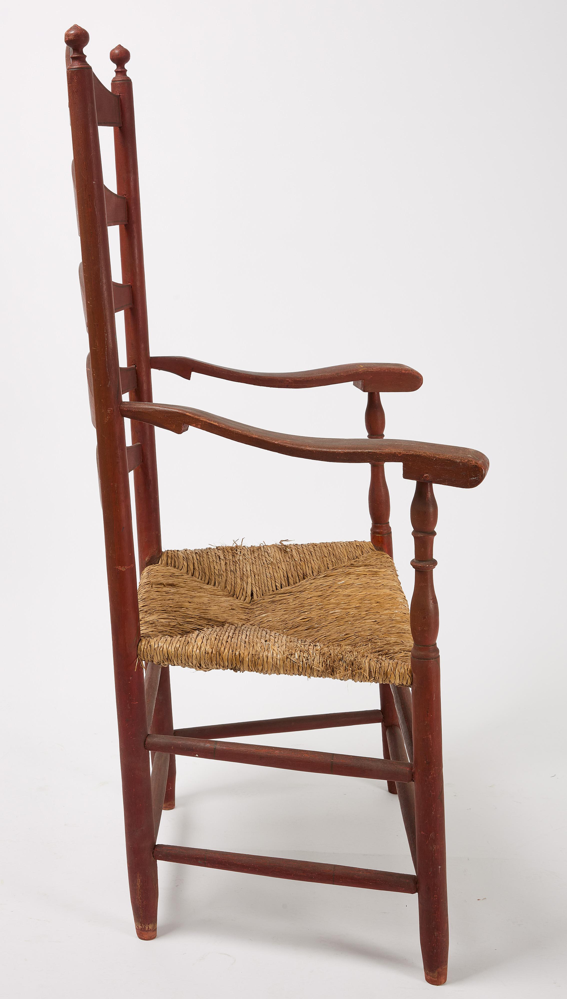 Excellent country ladder-back arm chair with original red paint with black highlights. Northeastern United Staes, circa 1820. Exceptional original condition.