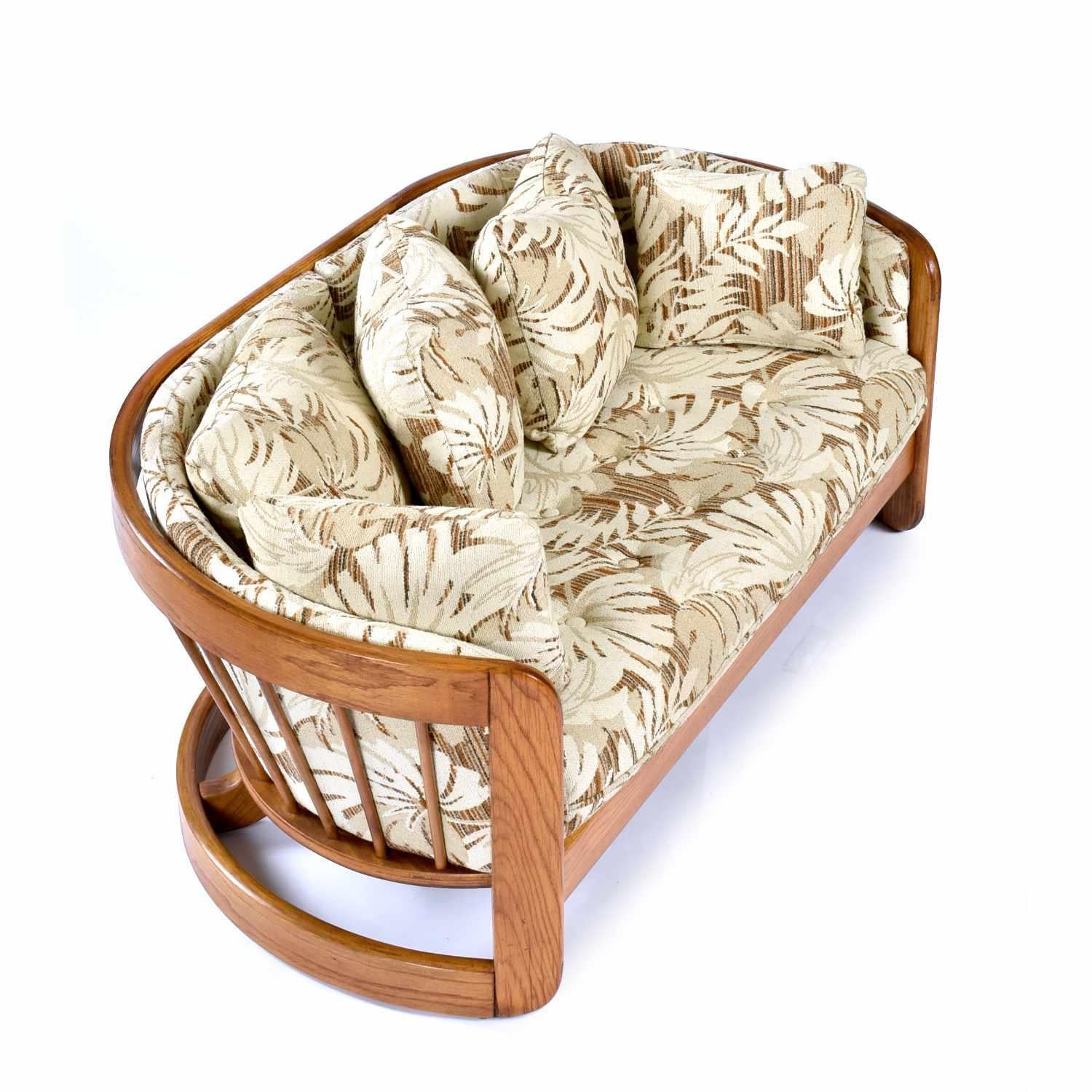 Vintage 1980s massiver Eiche geschwungenes Sofa von Howard Furniture. Das Sofasofa ist originalgetreu gepolstert. Der Stoff ist ein botanisches Muster in neutralem Hellbraun, Creme und Braun. Das Sofa ist mit seinem großen Sitzkissen und den