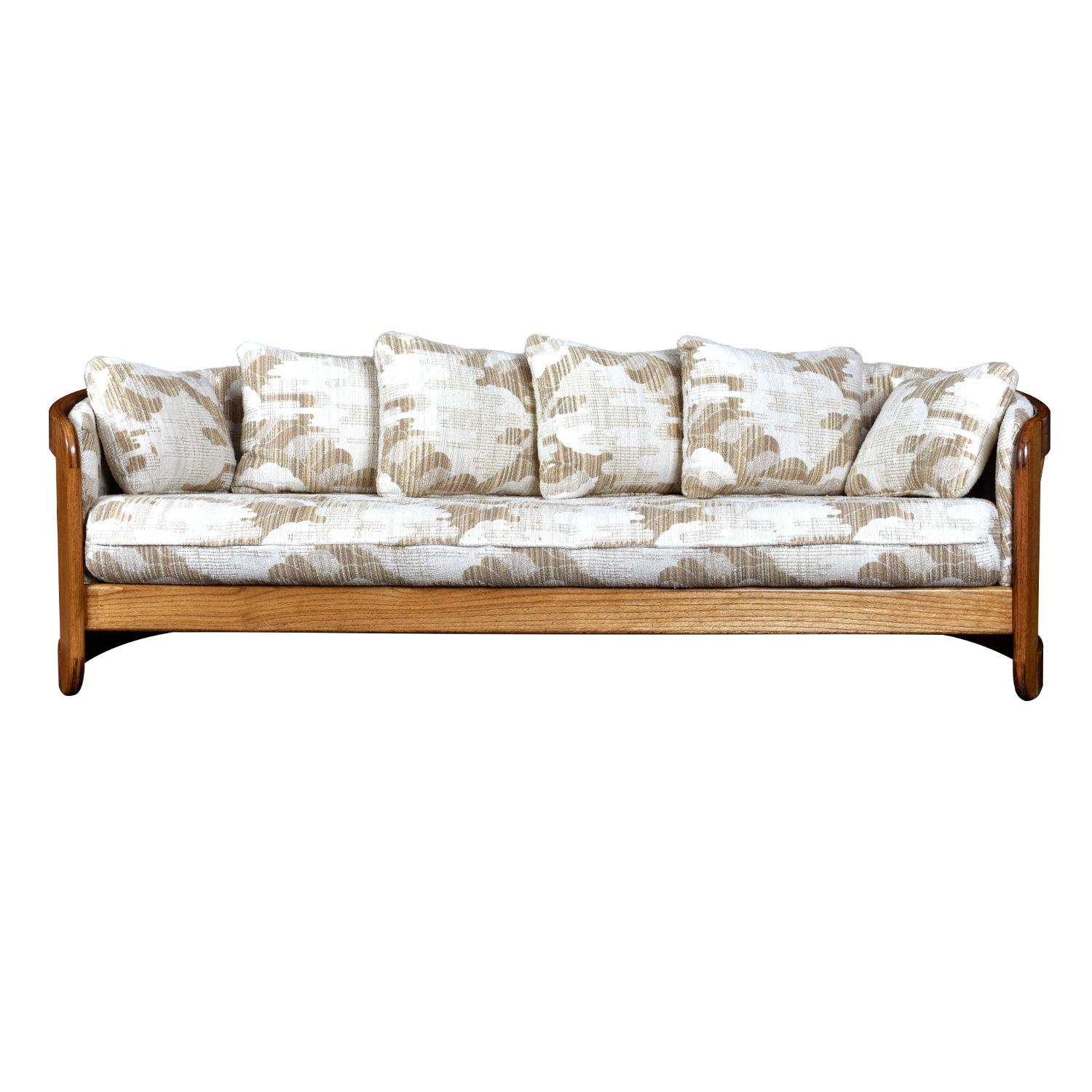 Comfort is king with this stylish vintage 1980s barrel shaped sofa by Howard Furniture. American made, solid oak throughout. The ultra cozy loveseat is wide and padded with plush pillows. The semi-circular surrounds the body, as if it’s giving you a