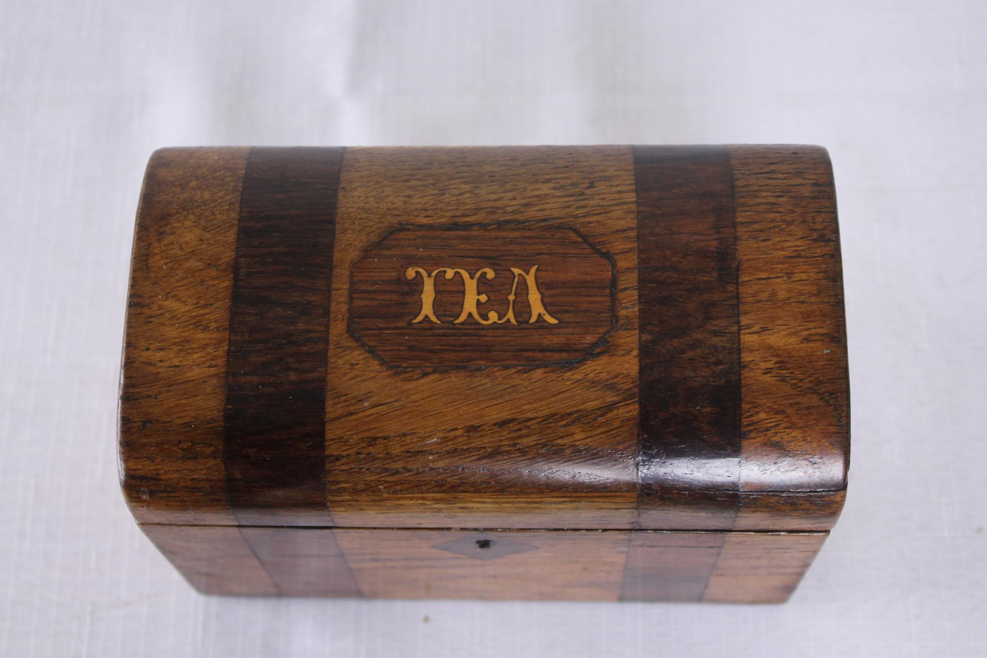 A small splendid Georgian tea caddy with TEA inlaid in satinwood. Both the oak box and the inlaid mahogany bands are in very good condition. The interior has its original compartment tops and the original interior paper. An outstanding example of