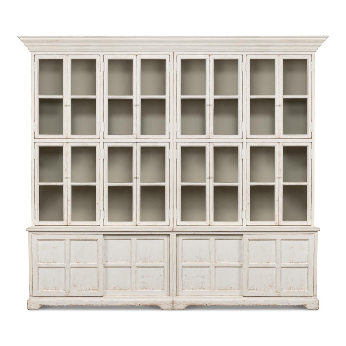 Country Painted bookcase with 12 sections, a molded cornice above glass door display storage bacinets with fixed shelves, the bottom with sliding doors. The white-painted pine cabinet has a hand-rubbed finish that is distressed and antique with a