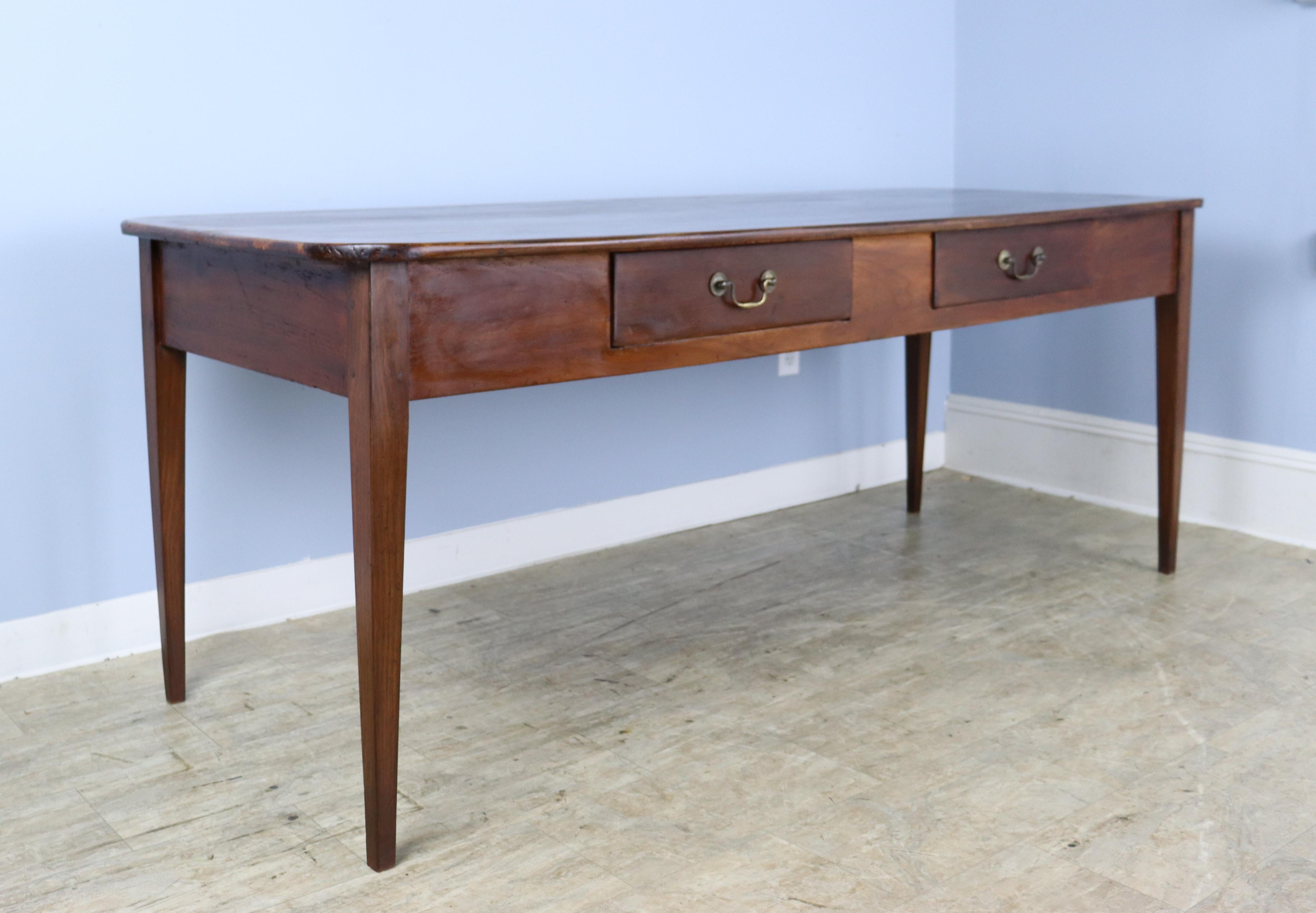 A handsome antique French farm table with a lovely top with hand cut rounded corners. The wood has very good color, grain and patina. Nicely tapered legs and two drawers in the extra deep apron, which measures 23.5 inches from the floor. There are