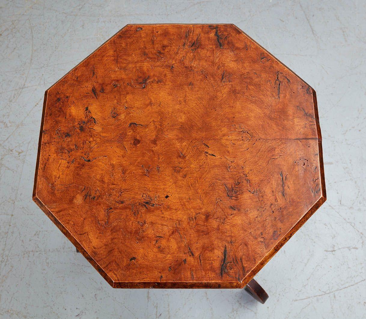 Good early 19th Century English country Regency octagonal wine table, the solid book-matched burl elm top with traces of parcel gilt on chamfered edge, standing on pencil chamfered shaft, the three scrolled legs joined to knotched base, the whole