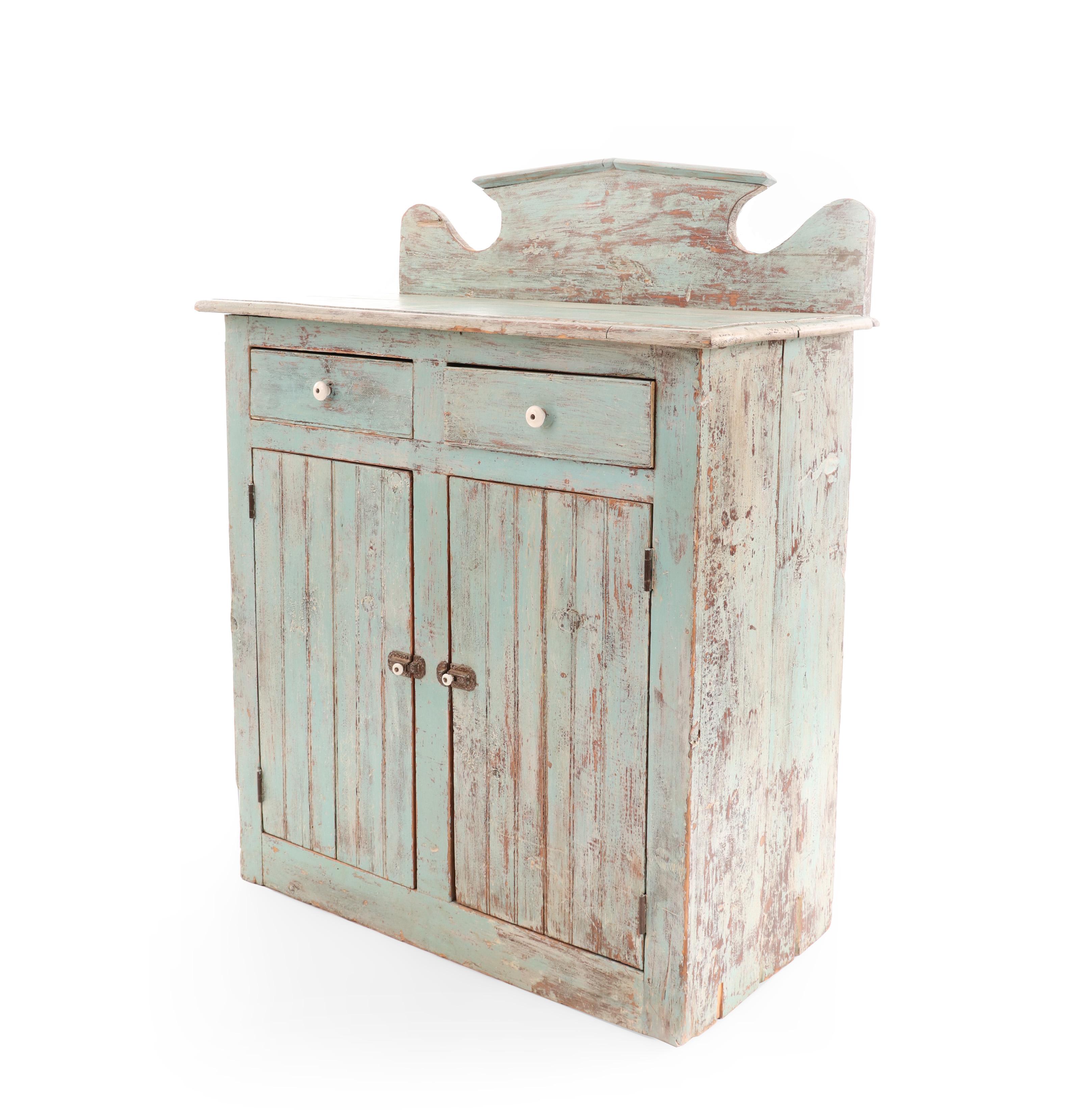 American country rustic blue painted wooden (Canadian / Ontario) cabinet with a back rail, two drawers with white ceramic pulls, above two cabinet doors.