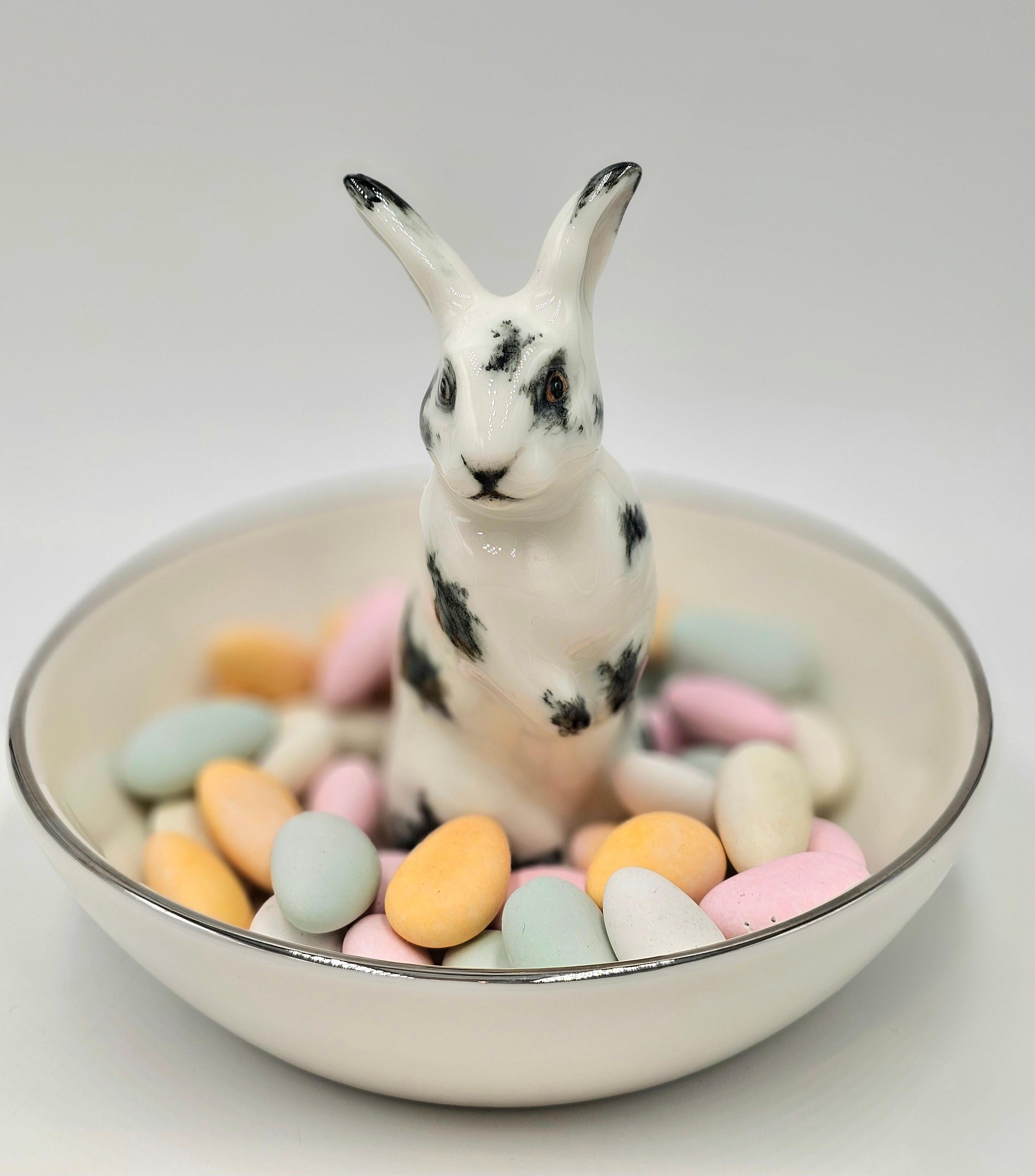 Completely handmade porcelain bowl with a hands-free naturalistic painted hare figure with black spots. The Easter bunny is sitting in the middle of the bowl for decorating nuts or sweets around. Rimmed with a fine platinum line. Completely handmade