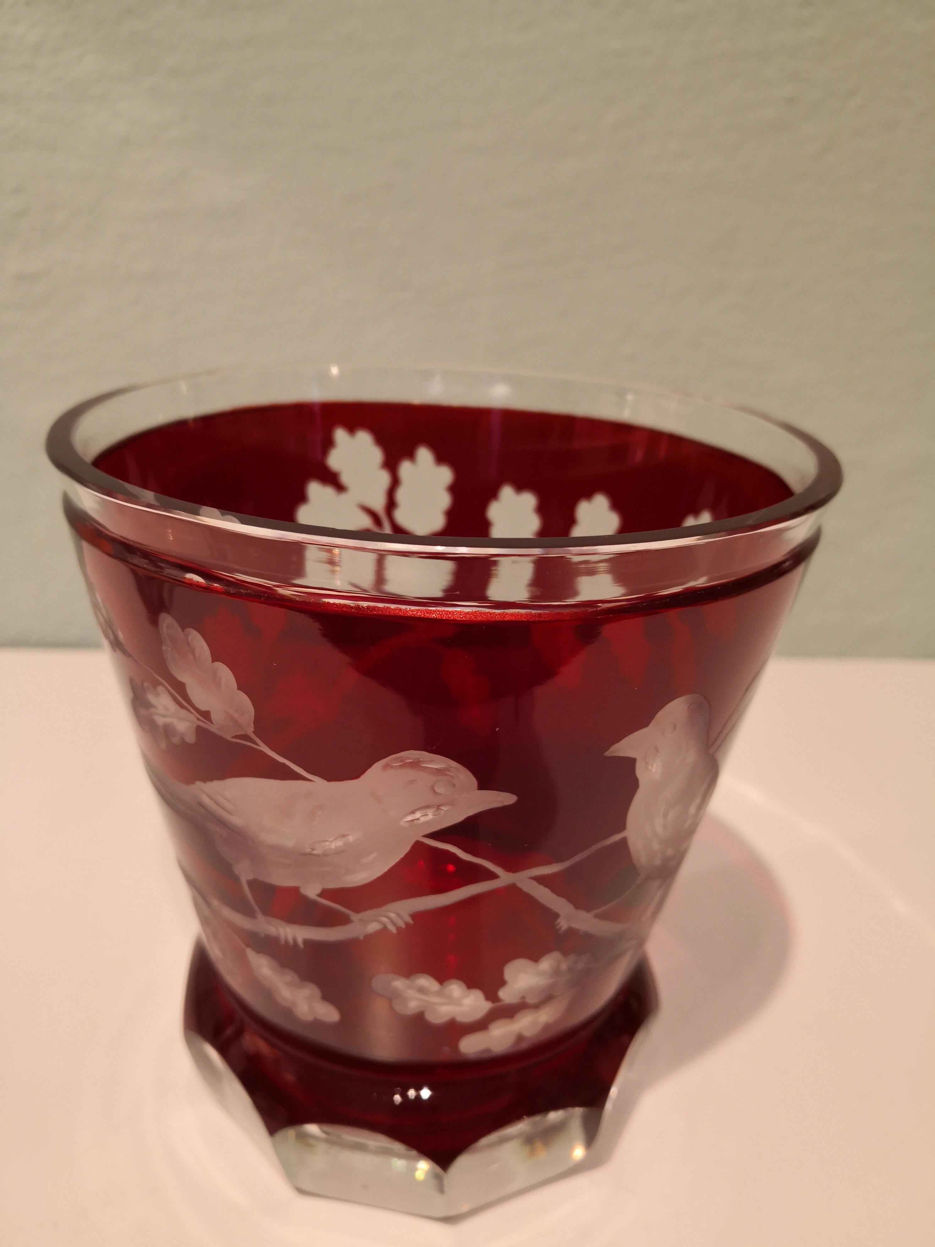 Handgeblasene Kristallvase/Laterne in leuchtendem Rot. Handgeschnitzt von bayerischen Glaskünstlern mit einem Vogeldekor im Landhausstil. Eine reiche Eichenlaubgirlande rundherum mit 2 handgravierten Vögeln. Kann mit einer Kerze als Laterne oder als