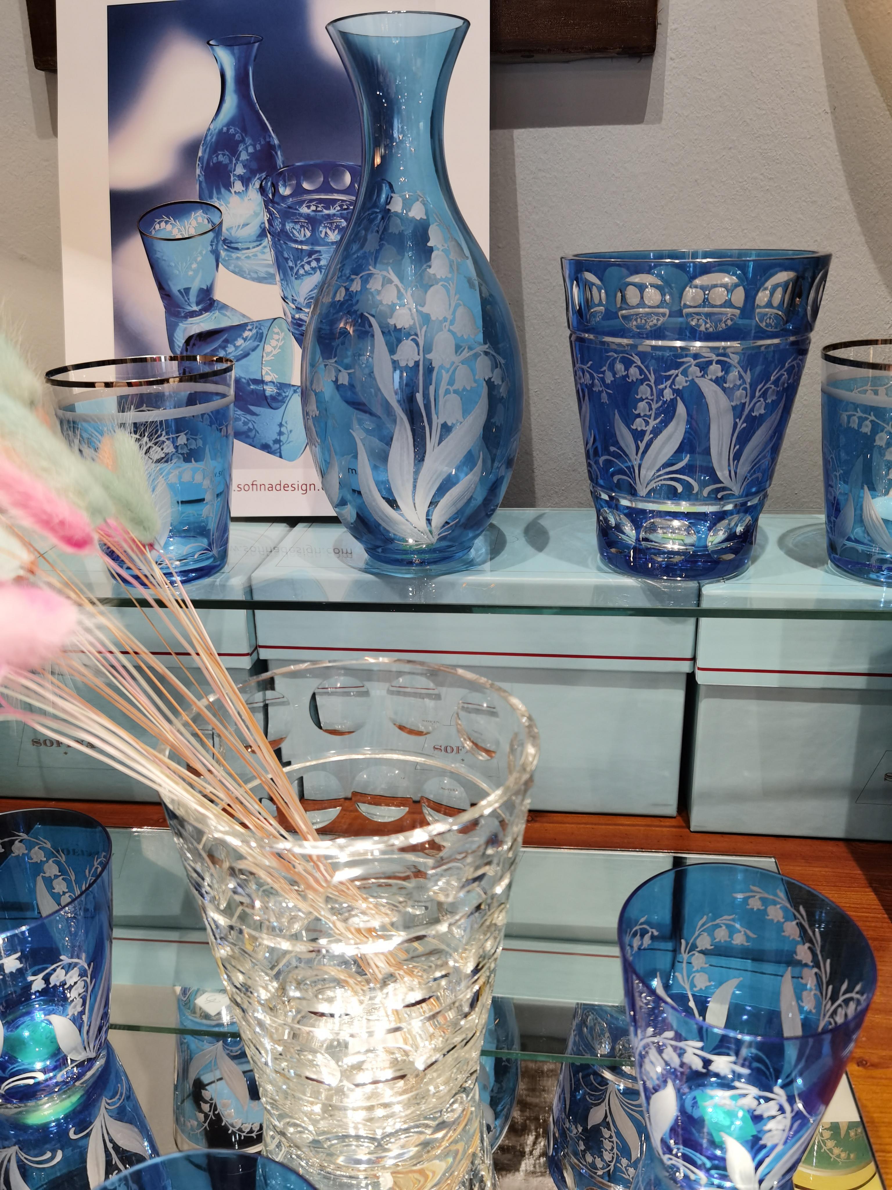 Hand blown crystal vase in light blue glass with lily of the valley decor all around. The blooms and leaves are hand-engraved by glass artists in Bavaria/Germany. The glass comes in a light blue color and can be ordered in different colors. Can be