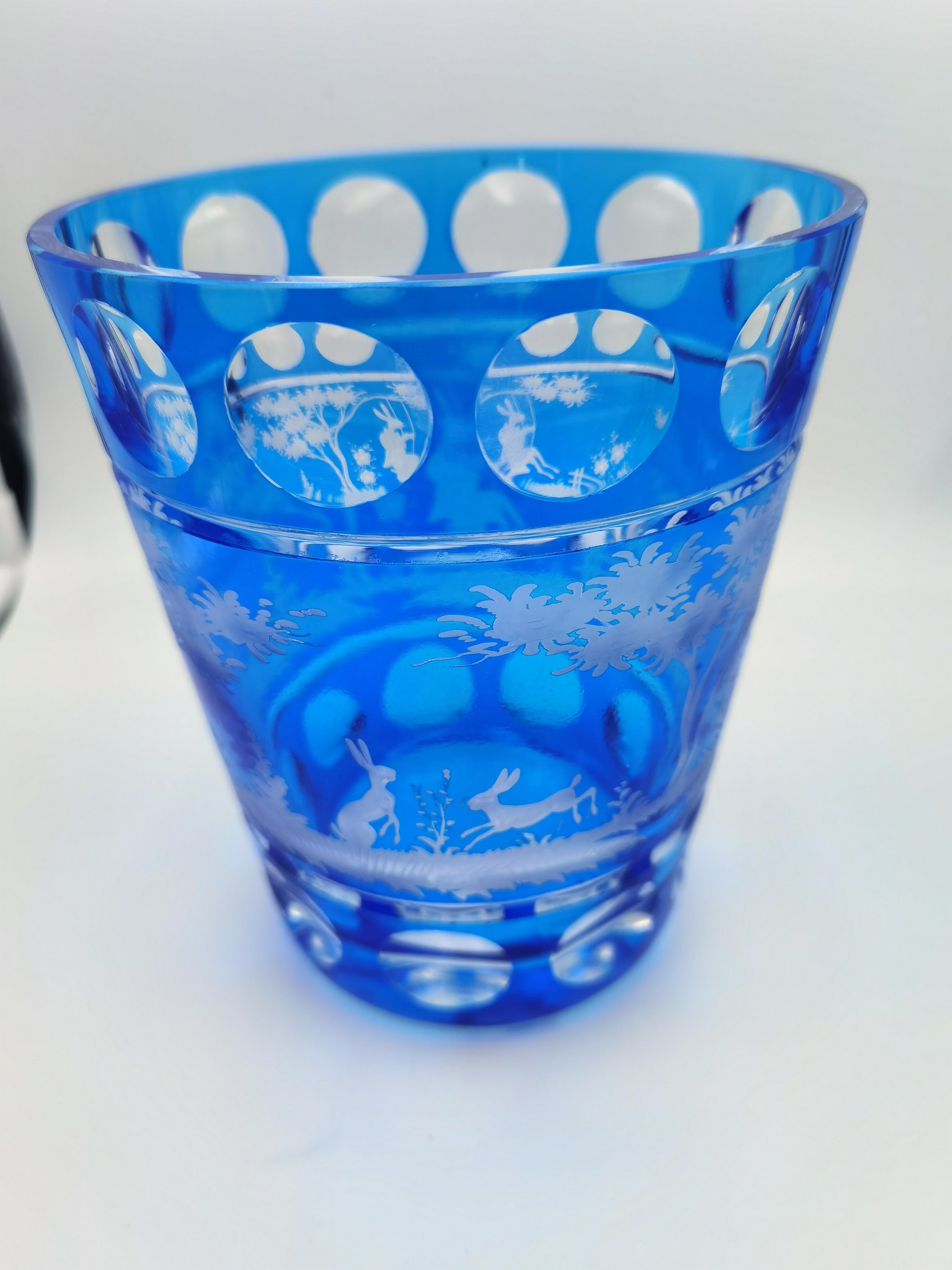 Vase aus mundgeblasenem blauem Kristallglas mit Osterhasendekor. Die Blätter, Hasen und Bäume werden von Glaskünstlern in Bayern/Deutschland handgraviert. Das hier gezeigte Glas hat eine dunkelblaue Farbe und kann auch in anderen Farben wie Grün und