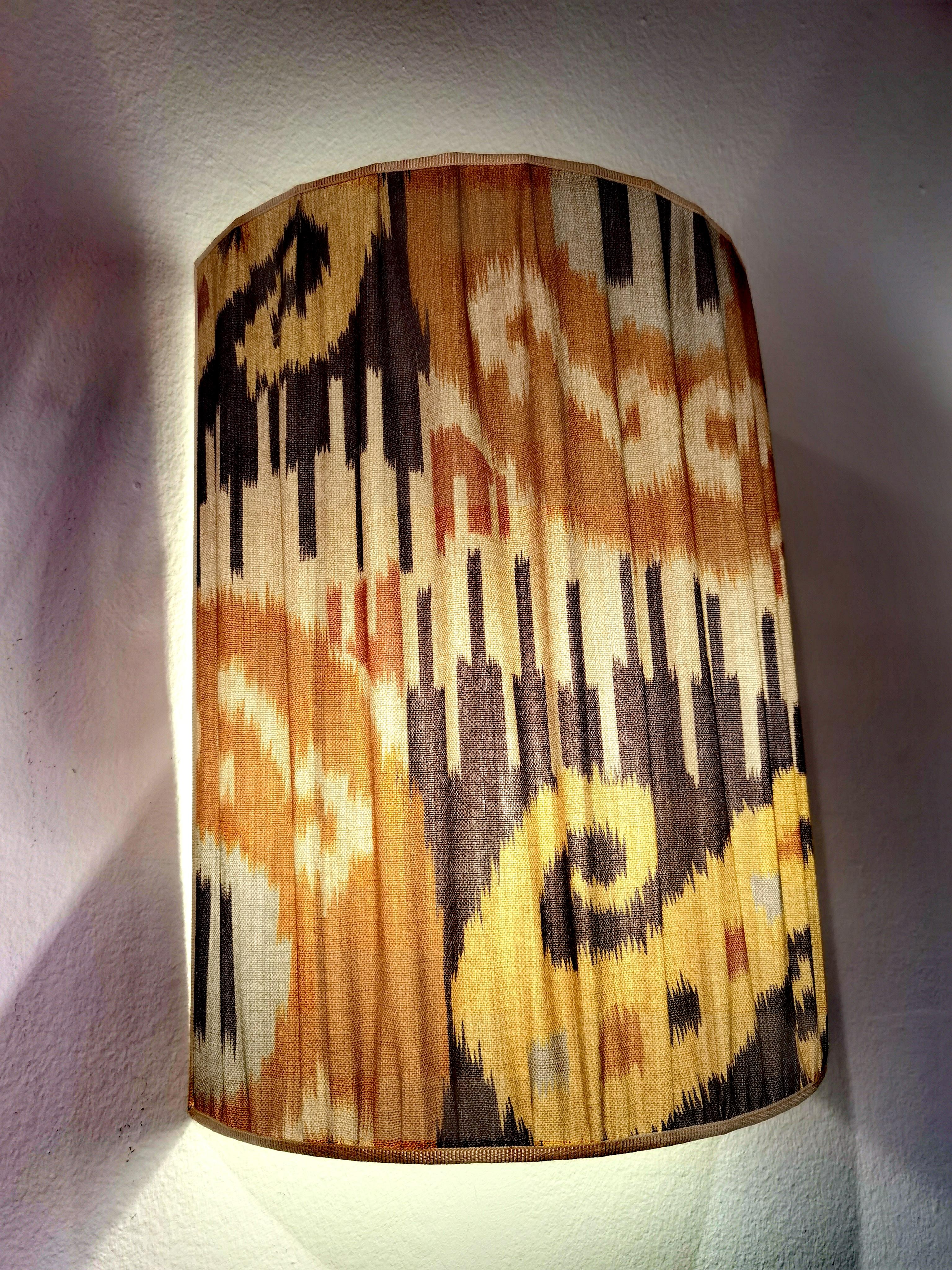 Paire d'abat-jour faits à la main, de style rustique, en tissu de coton à motif Ikat, de couleur marron et gris. Plissé et fabriqué à la main en Autriche.
Encadré d'un paspol fait main en soie beige. Des cornières en fer fabriquées à la main pour