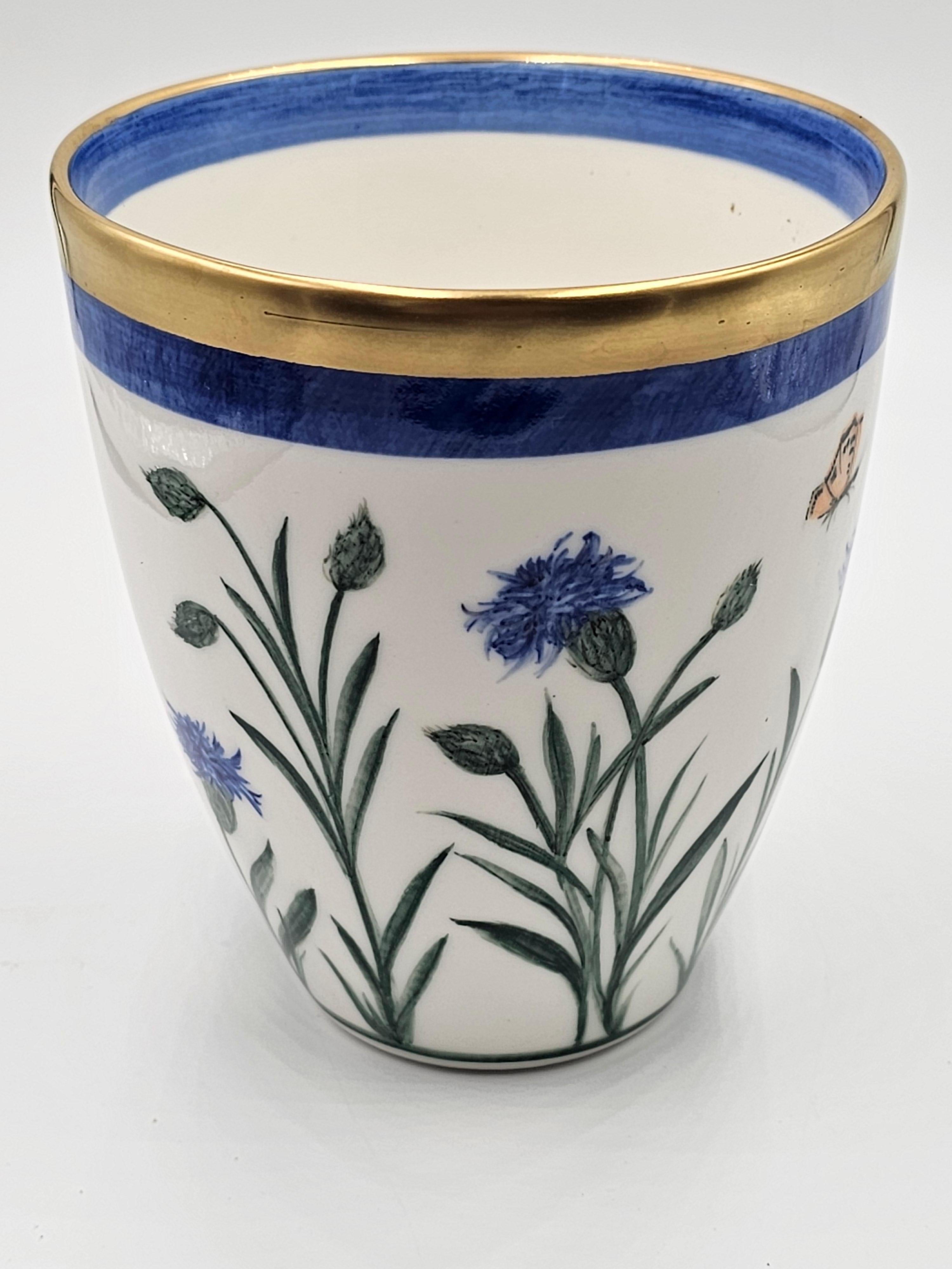 Freihändig bemalte Porzellanvase mit einem Blumendekor rundherum. Umrandet mit einem Platinrand. Komplett handgefertigt in Bayern/Deutschland mit einem exklusiven Dekor Kornblume in blauer Farbe für Sofina Boutique Kitzbühel.
Sieht schön aus mit