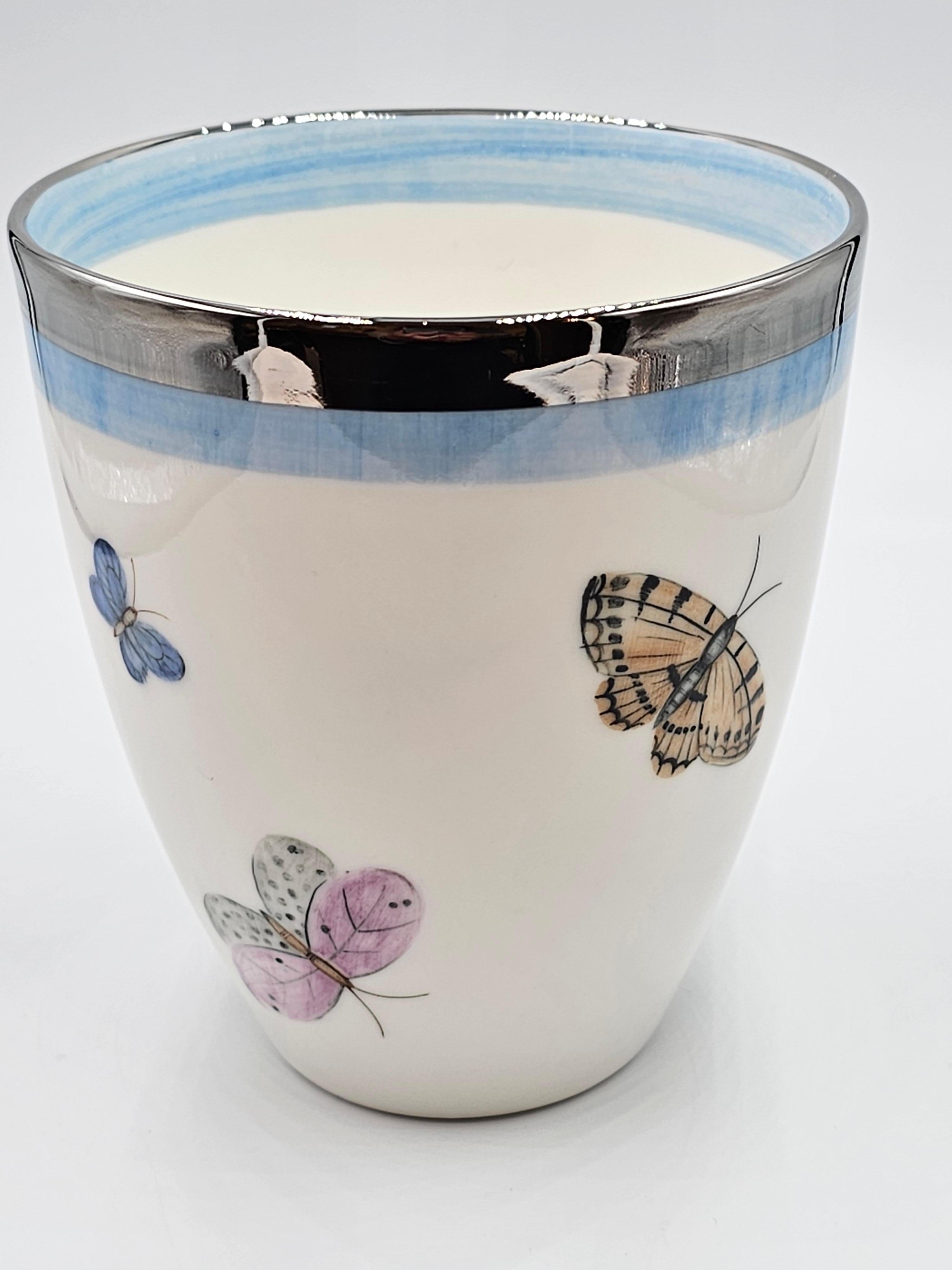 Freihändig bemalte Porzellanvase mit einem Schmetterlingsdekor rundherum. Mit einem hellblauen und einem platinfarbenen Rand versehen. Komplett handgefertigt in Bayern/Deutschland mit einem exklusiven Dekor für Sofina Boutique Kitzbühel.
Sieht schön