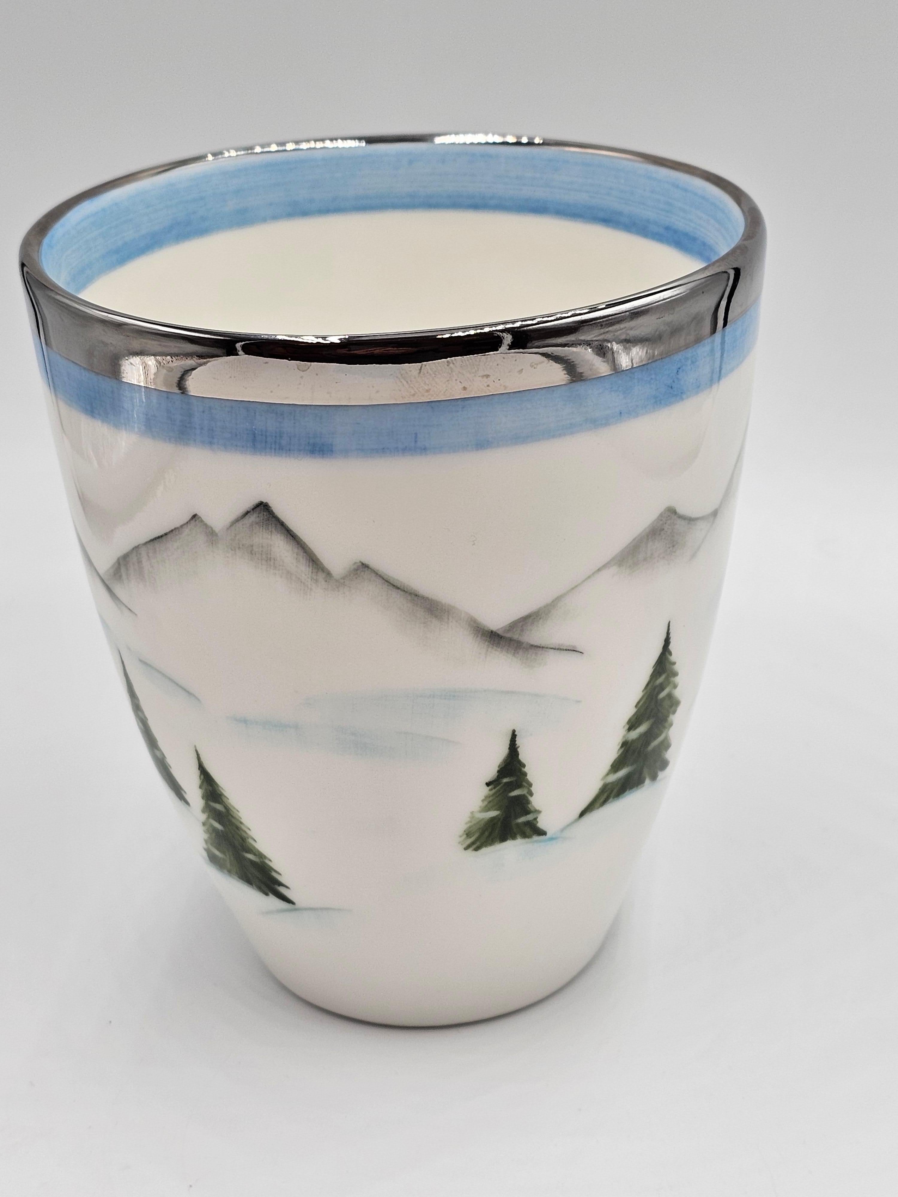 Vase en porcelaine entièrement fait à la main avec un décor de skieur peint à main levée tout autour dans le style Country. Mains libres peintes dans un design nostalgique avec un skieur, des arbres et une cabane dans les montagnes tout autour. Il
