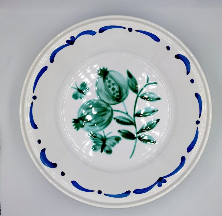 Large hands-free painted pottery dish in country style. Decorated with a handpainted green pomegranate decor in the center with butterflies and a hands-free painted garlande . The garlande can be ordered in different colors. Produced and handsfree