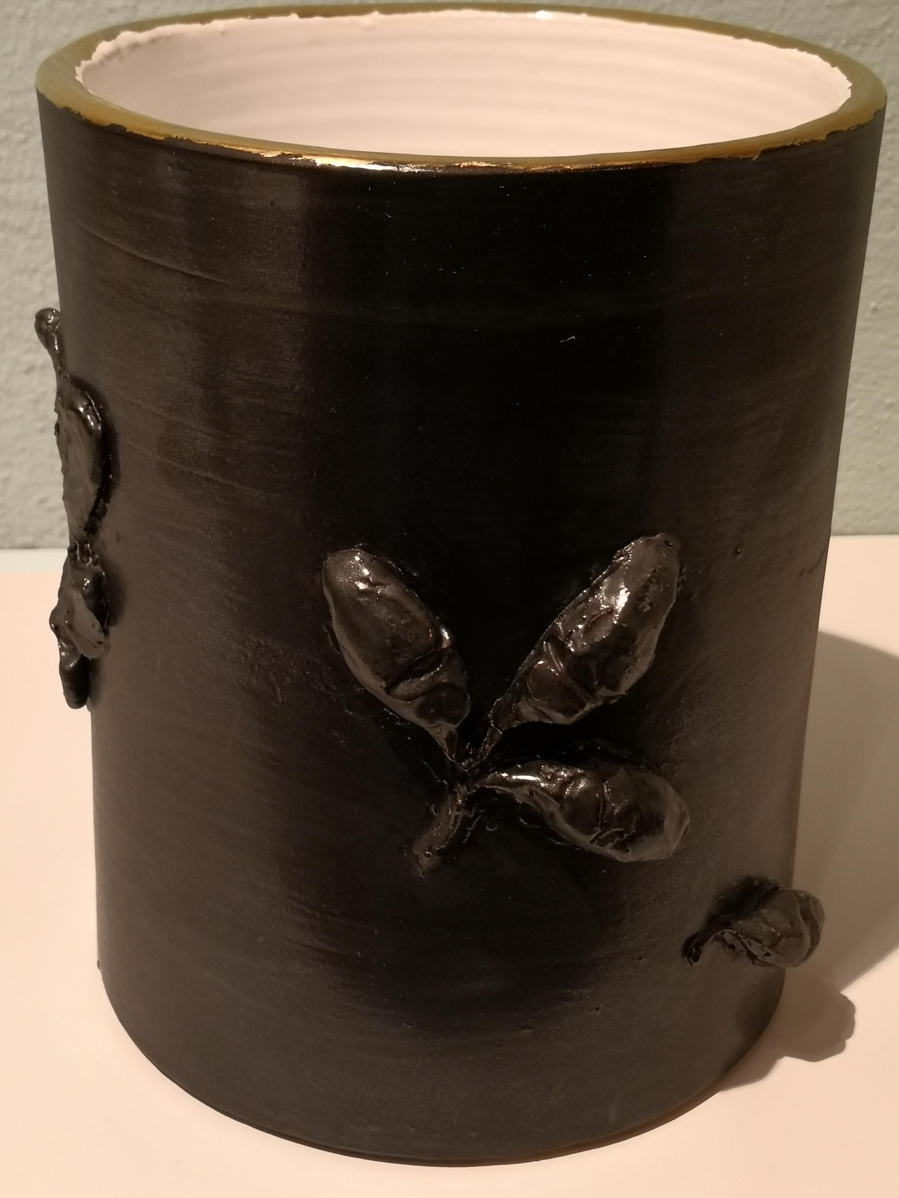Entirely handmade pottery vase in black earthenware. Hands-free formed in a strong straight form. Inside white glazed. All around a hands-free decor with naturalistic formed oak leaves and oaks. Rimmed with a gold line. in the bottom signed by the