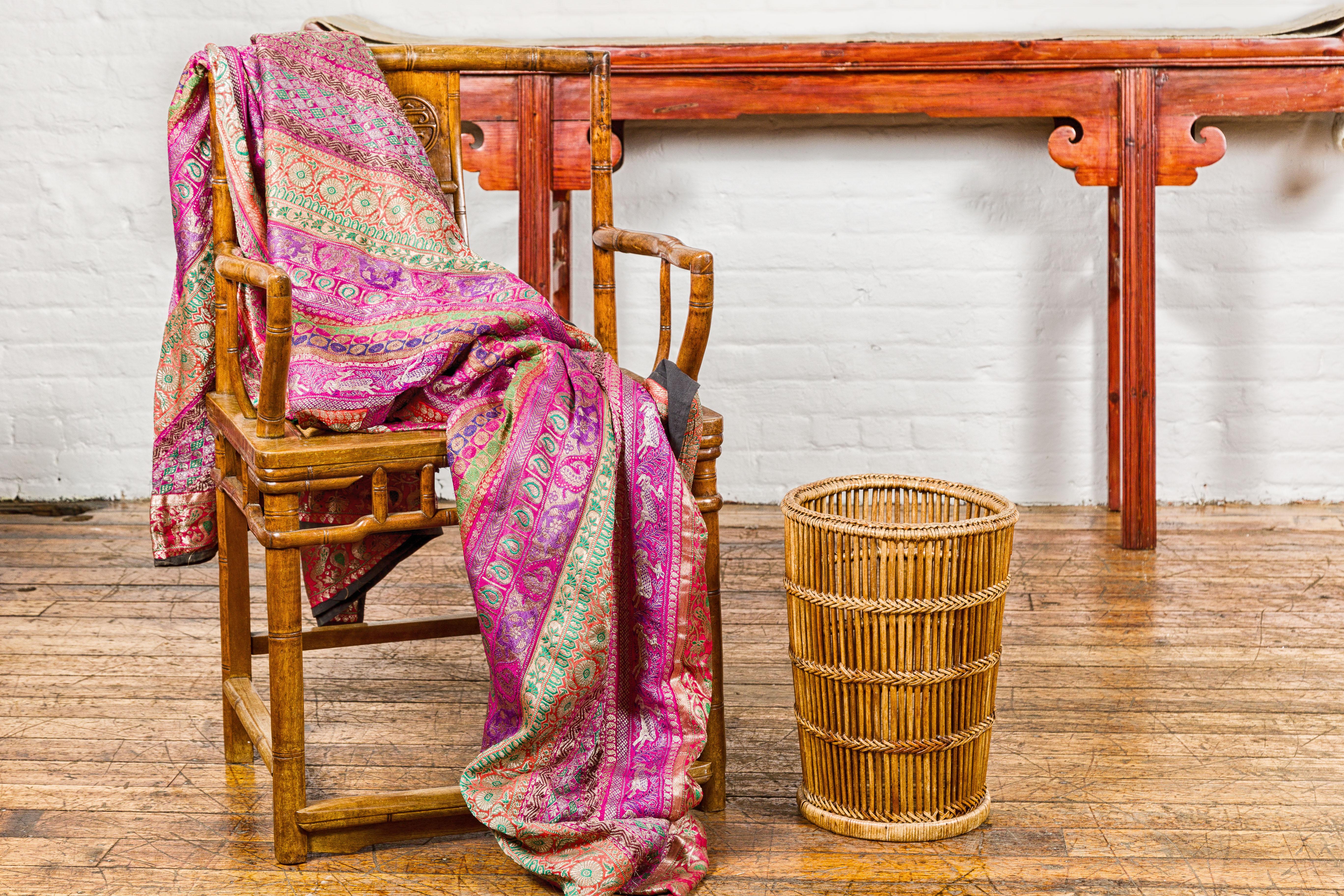 A Country style woven rattan waste basket with tapering lines. This vintage country-style woven rattan waste basket is a testament to timeless design and practicality. With its elegant tapering lines, this piece not only serves a functional purpose