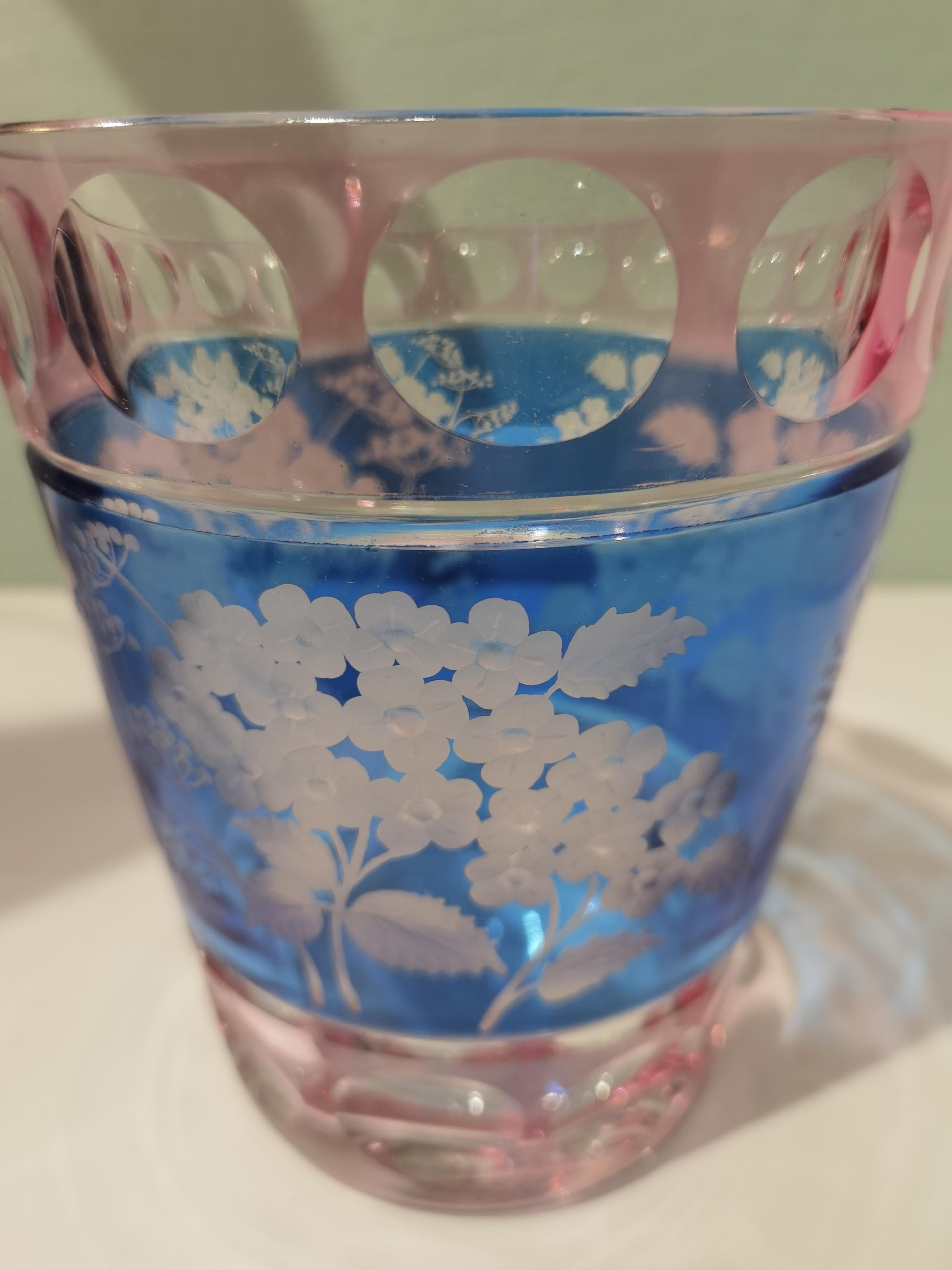 Vase aus mundgeblasenem Kristall in zartrosa und blauem Kristall mit einem Blumendekor im Landhausstil rundherum. Das Dekor zeigt Hortensienblüten im naturalistischen Stil. Vollständig mundgeblasen und handgraviert in Bayern/Deutschland. Das hier